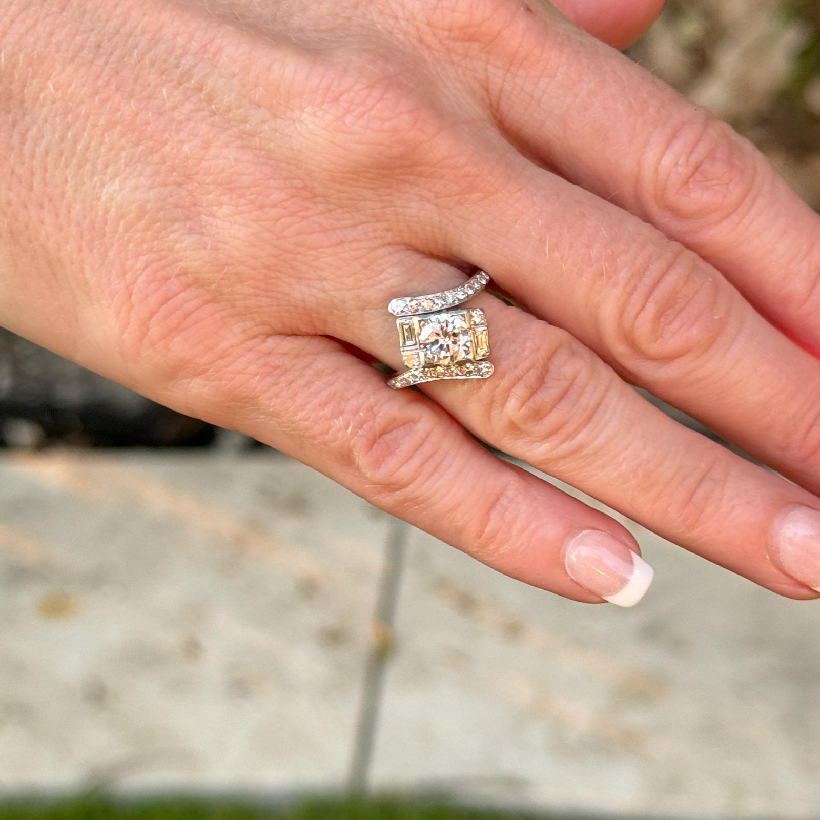 Diamant-Bypass-Ring aus den 1940er Jahren, handgefertigt aus 14 Karat Weißgold. Der Vintage-Ring besteht aus einem runden Diamanten mit Brillantschliff von etwa 0,88 Karat und 18 seitlichen Diamanten mit einem Gesamtgewicht von etwa 0,44 Karat. Der