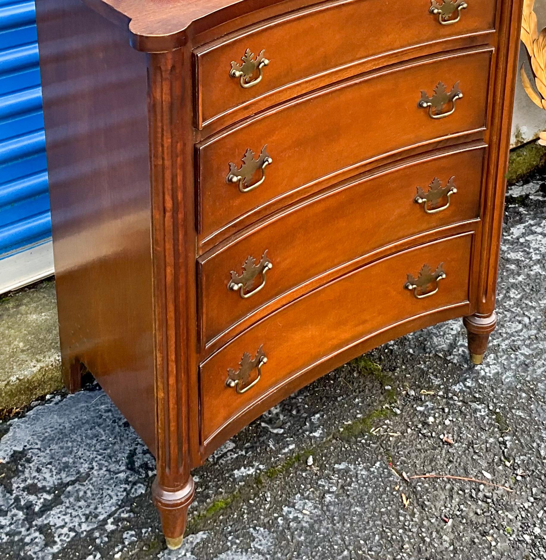 This is a pair of diminutive Chinese Chippendale style chests with concave fronts and brass capped feet. They were bench made pieces by a Pennsylvania company called Schell. The chests would work from bedside to side table and pack a punch for their