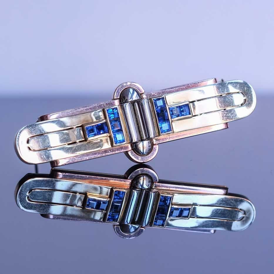 Double clip brooch 1940s set in 14ct three tone gold with sapphires. Can be worn both as brooch in one piece or can be separated and used as double clip.

Highlights
- Three tone 14ct gold
- 1940s
- Brooch and double clip

Measurements
- Length 6.6