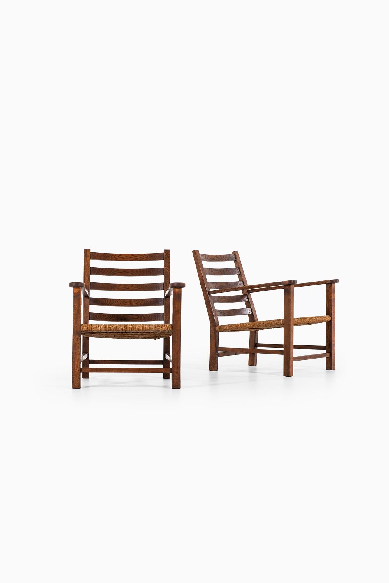 A pair of easy chairs in oak and hemp string. Probably produced in Sweden.