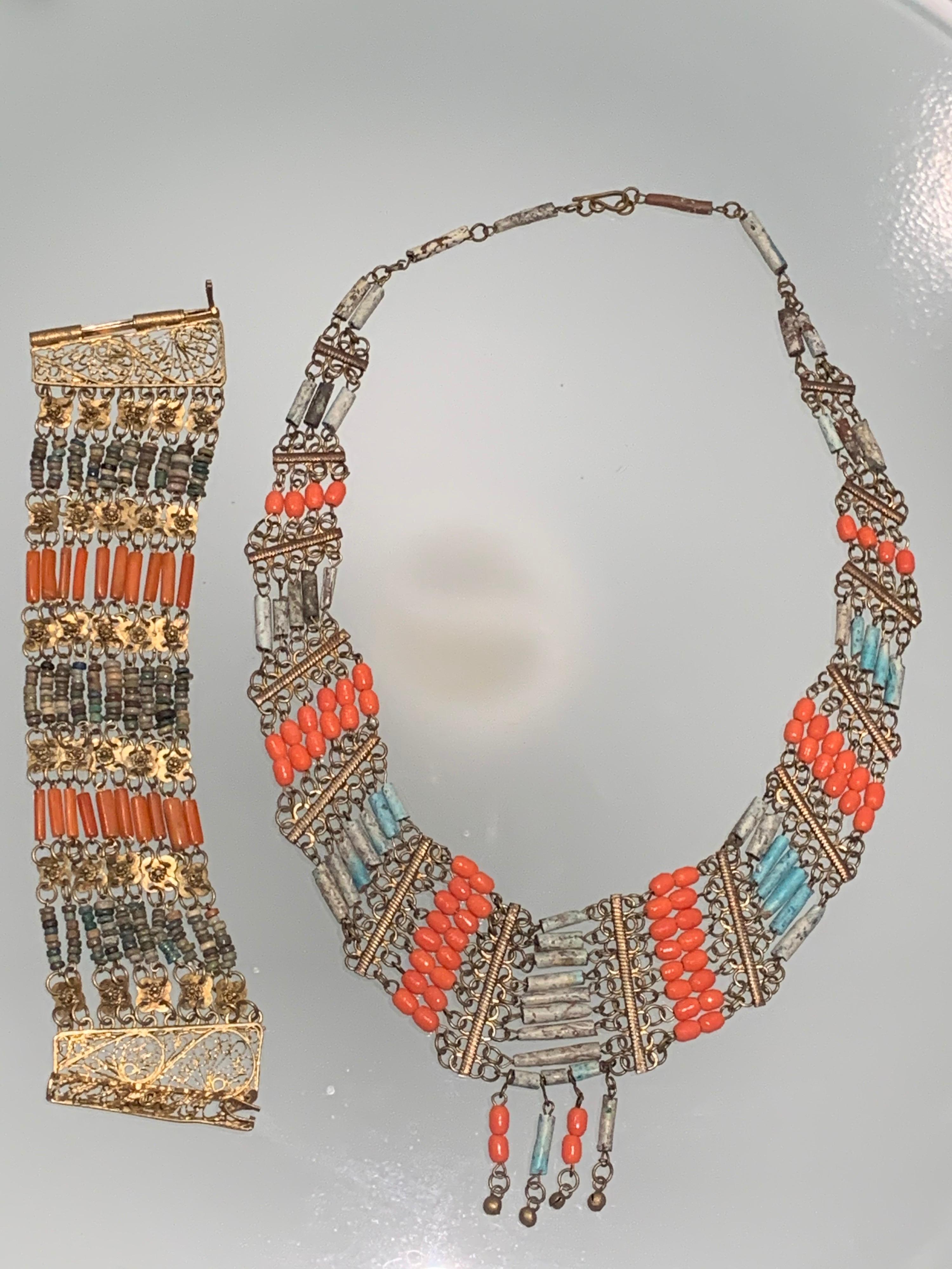 1940s Egyptian clay and brass filigree bib necklace and cuff pairing:  Cuff is wide with a filigree hinge & pin closure. Bib necklace is graduated with coral and turquoise hues in clay beads.  At center of bib are 4 traditional pendant ornaments. 