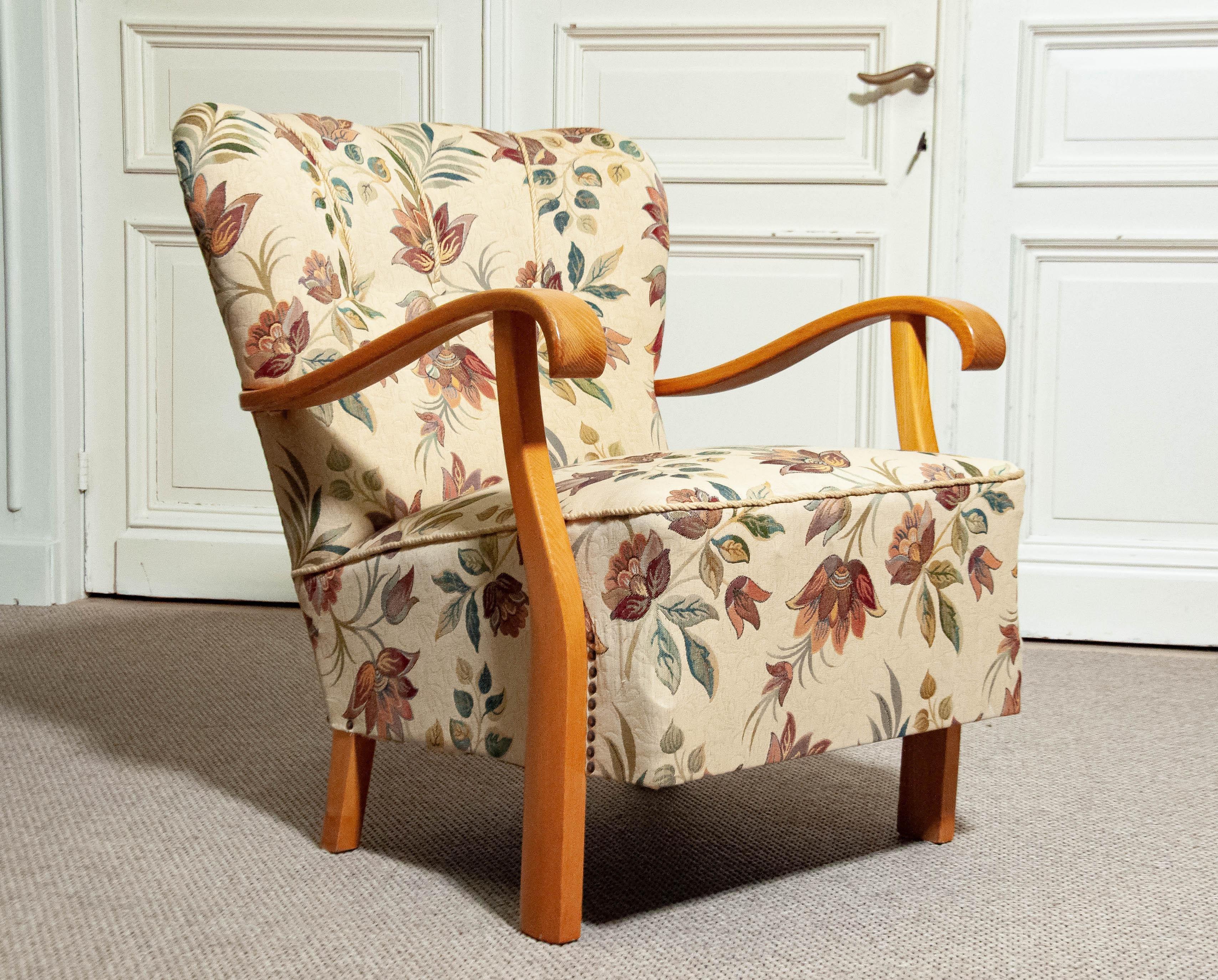 Dieser elegante schwedische Sessel aus der ersten Hälfte des 20. Jahrhunderts ist fachmännisch aus reichem Ulmenholz gefertigt und zeigt zeitloses skandinavisches Design. Der Stuhl ist mit einem eleganten Jacquard-Stoff aus den späten 1960er Jahren
