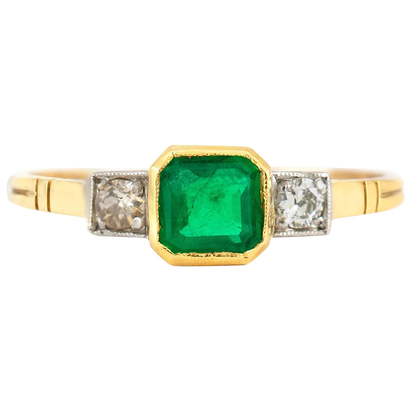 1940er Jahre Verlobungsring mit Smaragd in der Mitte und zwei runden Diamanten auf der Seite