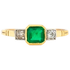 1940er Jahre Verlobungsring mit Smaragd in der Mitte und zwei runden Diamanten auf der Seite