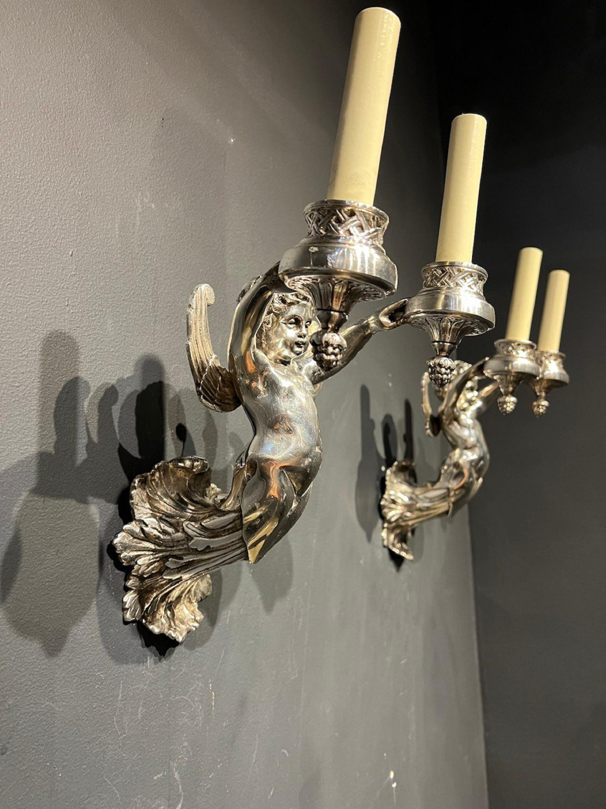A pair of 1940’s English silver plated sconces angel shape with two lights.  In very good vintage condition. 

Style: English Traditional

Dealer: G302YP 
 