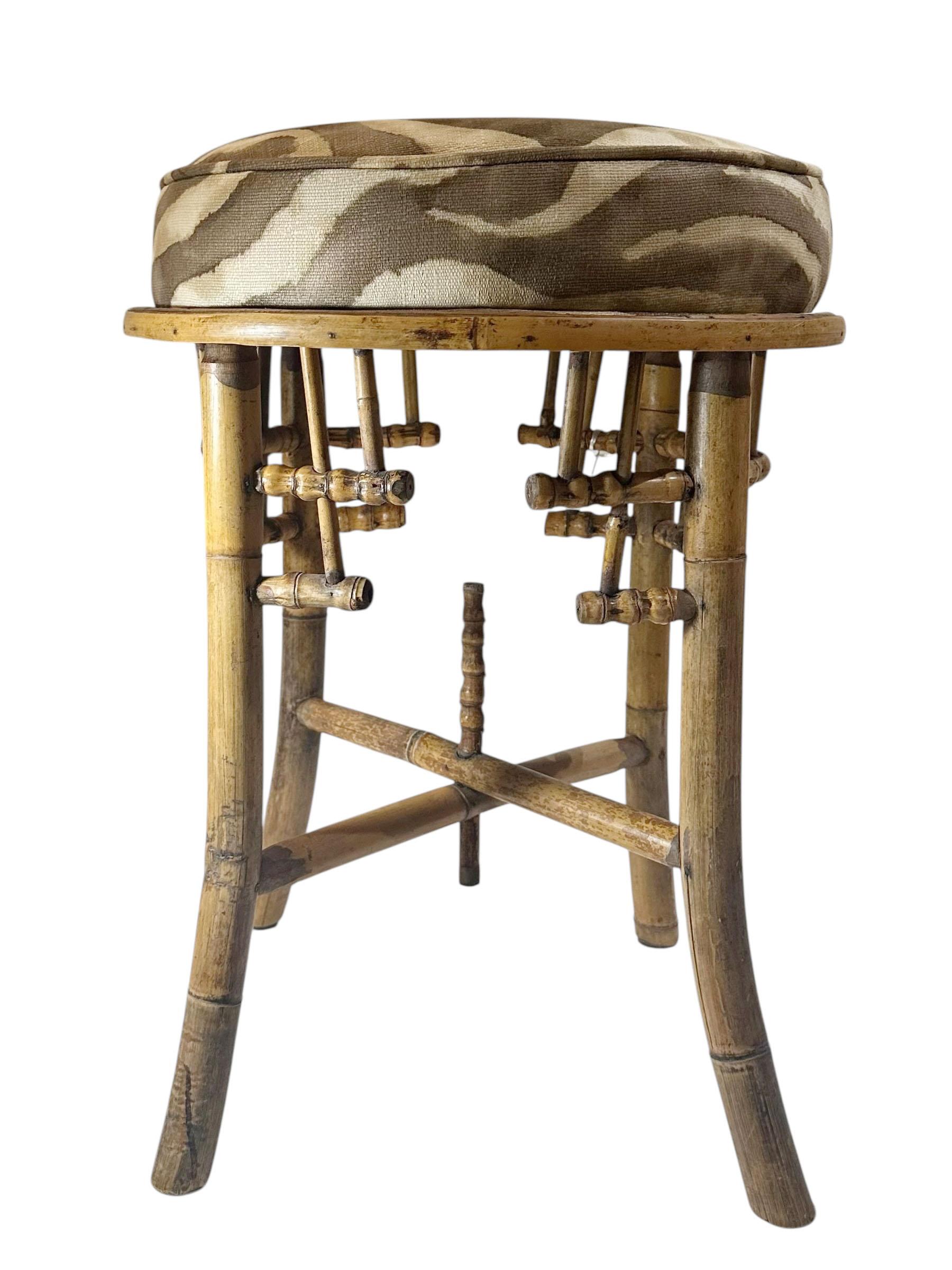 An elegant English bamboo footstool, dating to the early 1940s, upholstered in a vintage Clarence House linen fabric. The stool reflects the refined English taste of the period, blending natural bamboo craftsmanship with the sophistication of one of