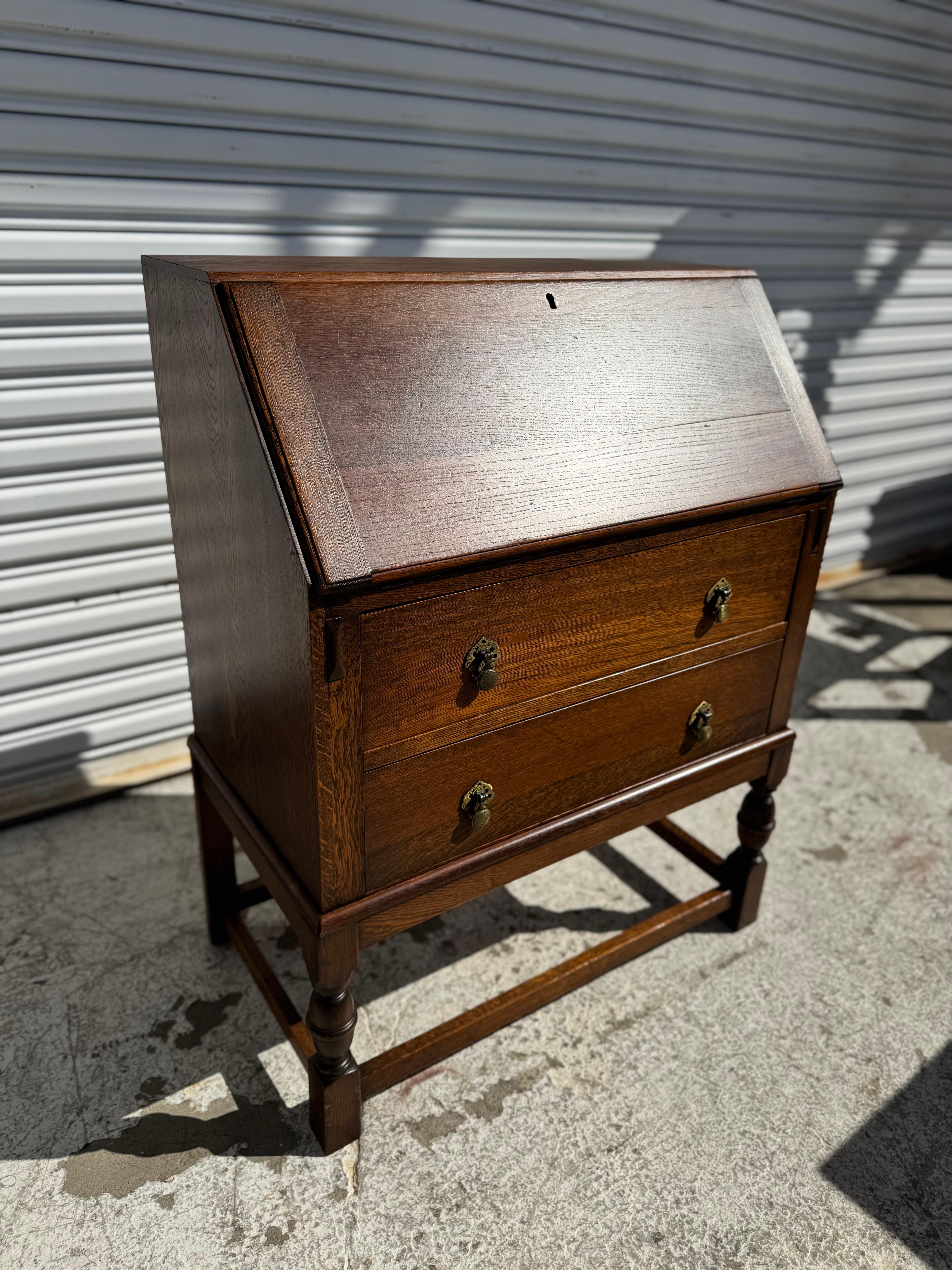 Dies ist ein Sekretär aus englischer Eiche mit Tropfenfront.
Die Beine sind gedreht und im William-and-Mary-Stil gestaltet.
Die Beine sind mit Streckern versehen, die das Stück verstärken und ihm zusätzliche Stabilität verleihen.
Der Sekretär hat 2