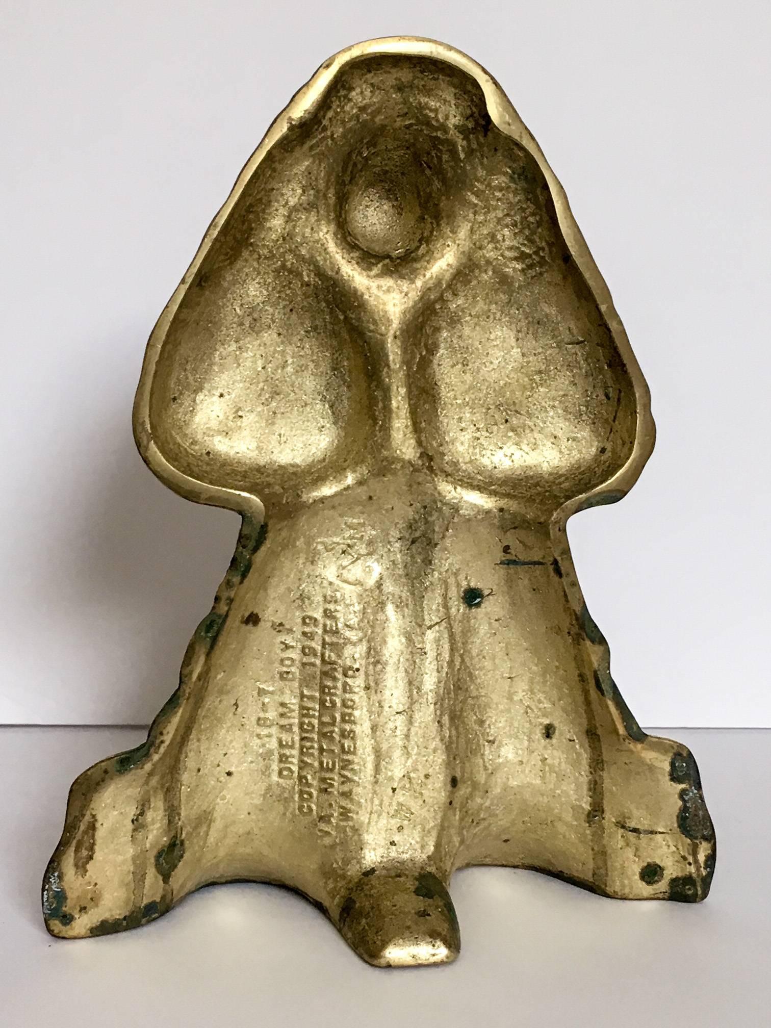A heavy solid cast brass dog doorstop titled 