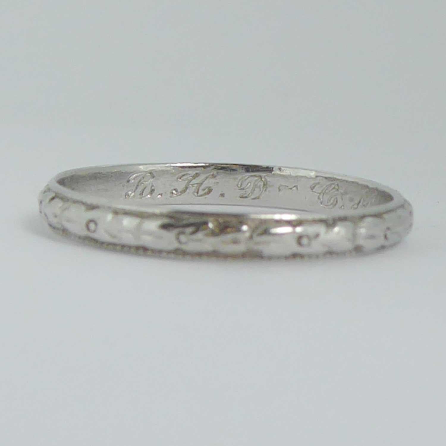 A beautiful vintage wedding ring from the 1940s with floral patterned sections all around the centre of the band and with milled grain edges.  The inside of the band bears the dedication 