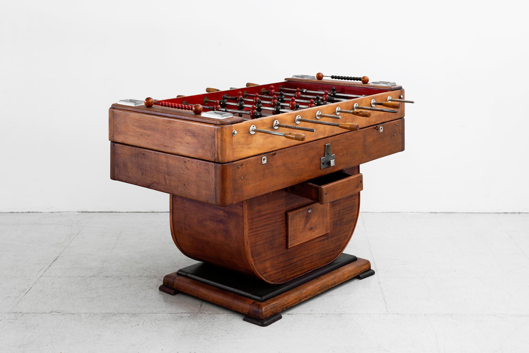1930s working football table in solid oak and polished aluminum.
Four metal ashtrays at corners, blue and red platers with red glass matt.
Wonderful patina.


  