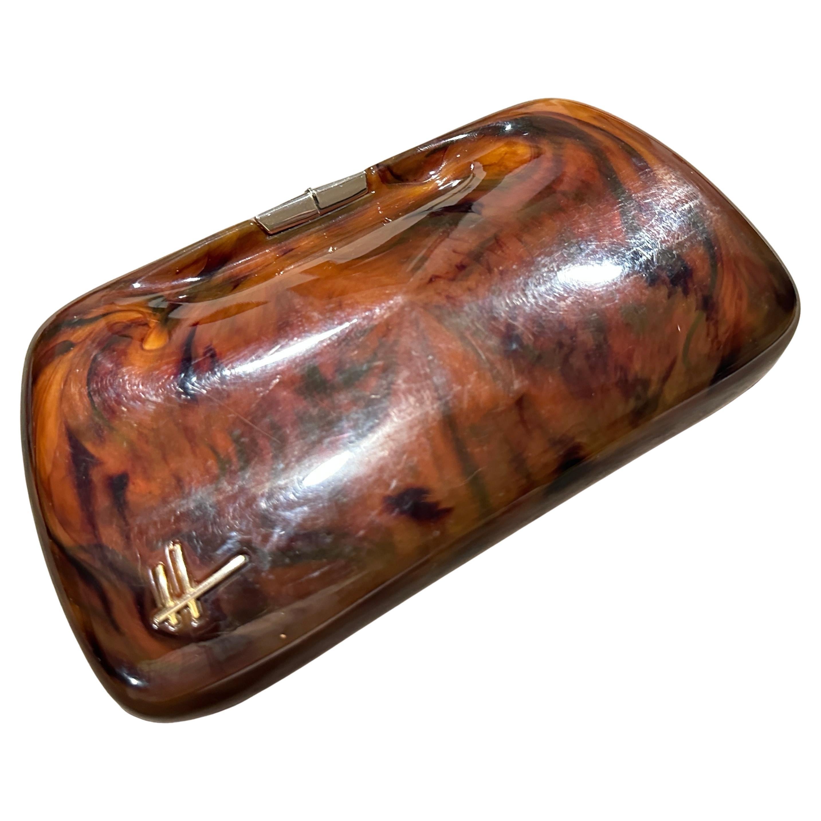 This stunning piece is a beautiful example of Art Deco and post-war design, showcasing the sophisticated use of Bakelite in high fashion.
The bag features a sleek, structured body crafted from a high-gloss Bakelite in a beautiful faux tortoiseshell