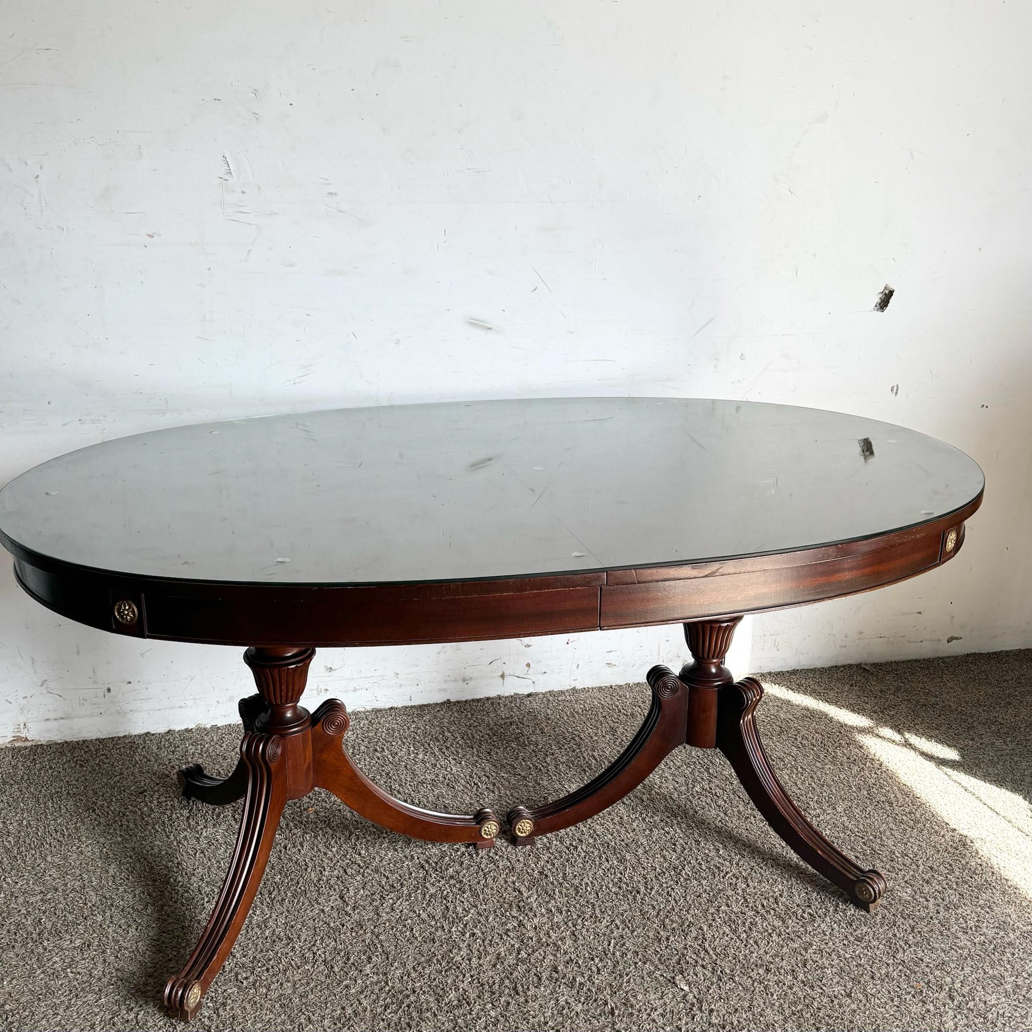 La table de salle à manger en acajou flammé des années 1940 de RWAY met en valeur la riche beauté de l'acajou flammé avec un plateau en verre protecteur. Ses élégants pieds incurvés et ses accents en laiton illustrent un savoir-faire intemporel,