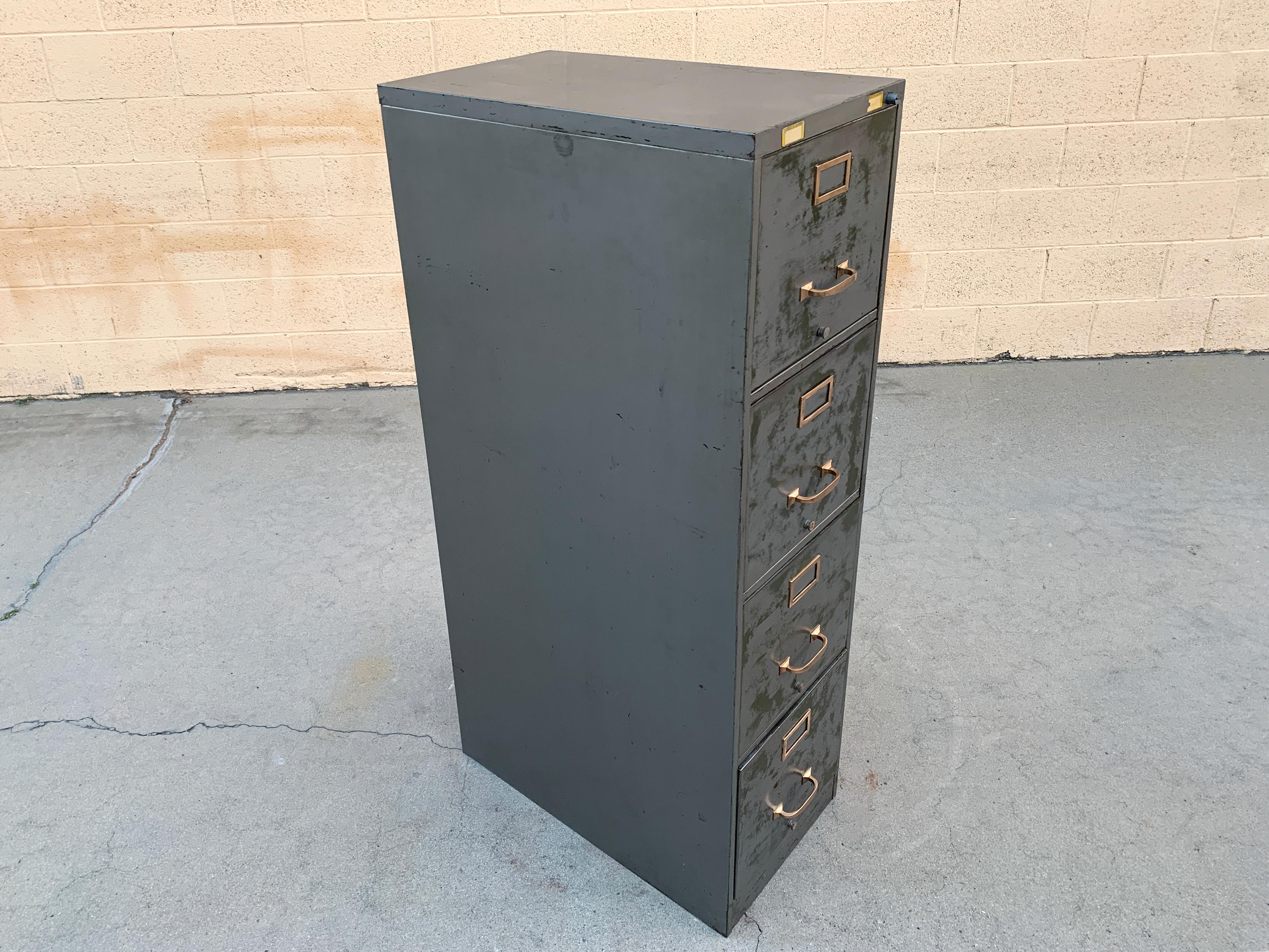 1940s steel file cabinet with a distressed finish and brass hardware polished to a shine. 4-drawer vertical configuration with lock (no key). Classic tanker styling! Salvaged from the labs of UCLA, cool old labels at top.

Solid, heavy-duty