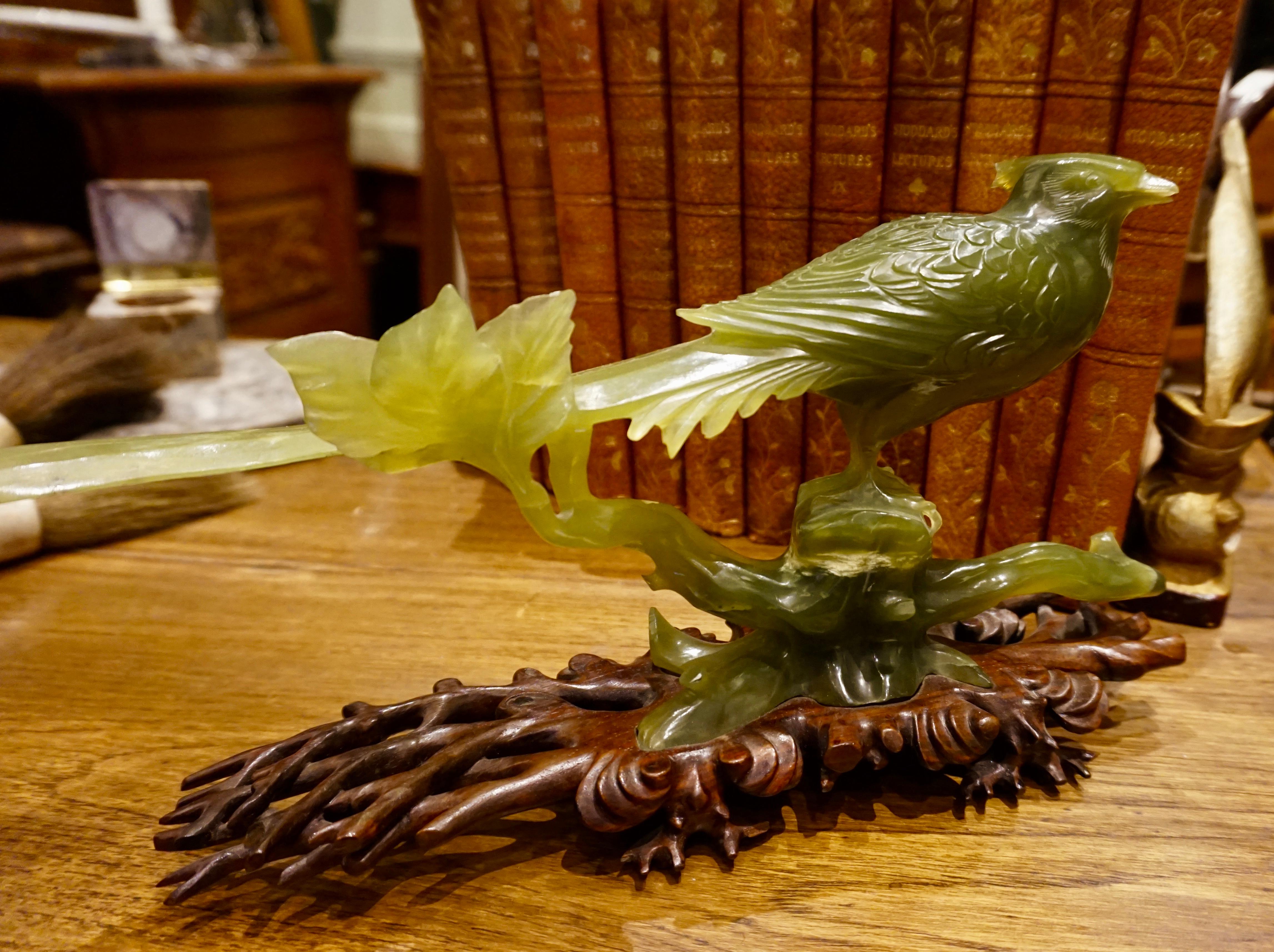 Chinese serpentine hand carved magpie, circa 1940s.
Singular carved magpie from a single piece of serpentine with incredible detail down to the talons. Sits on original hand carved rosewood stand. One small chip behind head feather consistent with