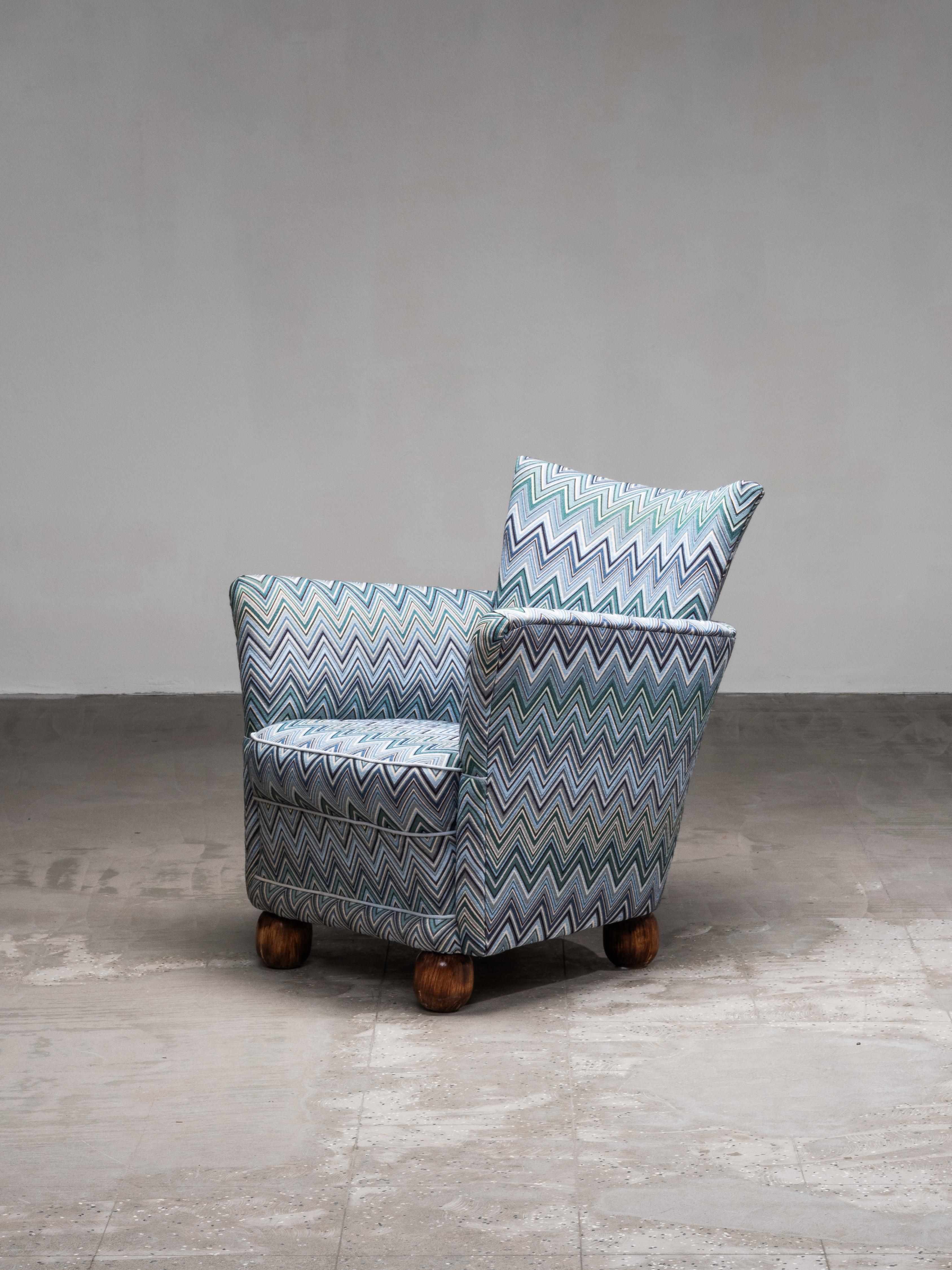 Ce charmant fauteuil club Art déco finlandais des années 1940 allie l'élégance de l'époque à une sensibilité ludique et moderne. Nouvellement revêtue d'un tissu vibrant à motif chevron, la chaise présente un rythme géométrique audacieux qui