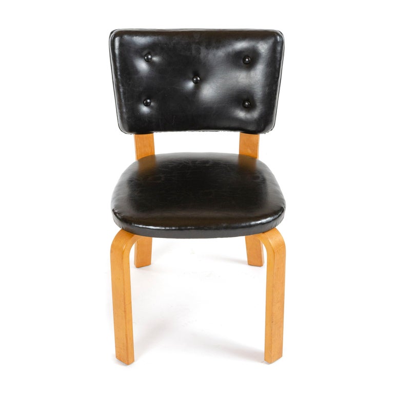 A dining chair in laminated birch with newly upholstered black leather seat and back.
