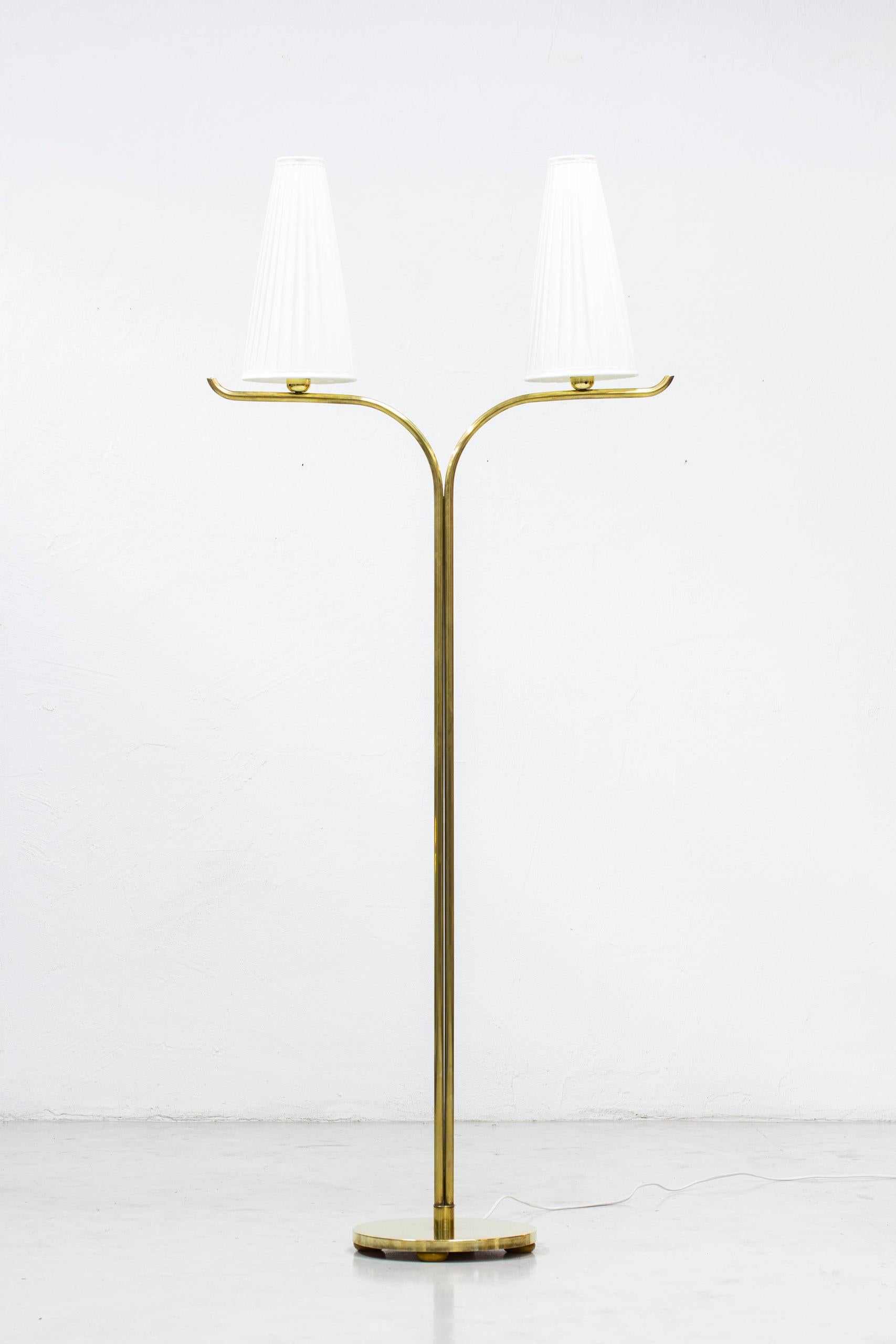 Swedish modern floor lamp by Gustaf Axel Berg. Produced by his own workshop G. A berg & Co in Stockholm, Sweden in the 1940s. Made from polished brass and shades with new hand sewn chintz fabric in creme white. Light switch on the chord. Very good