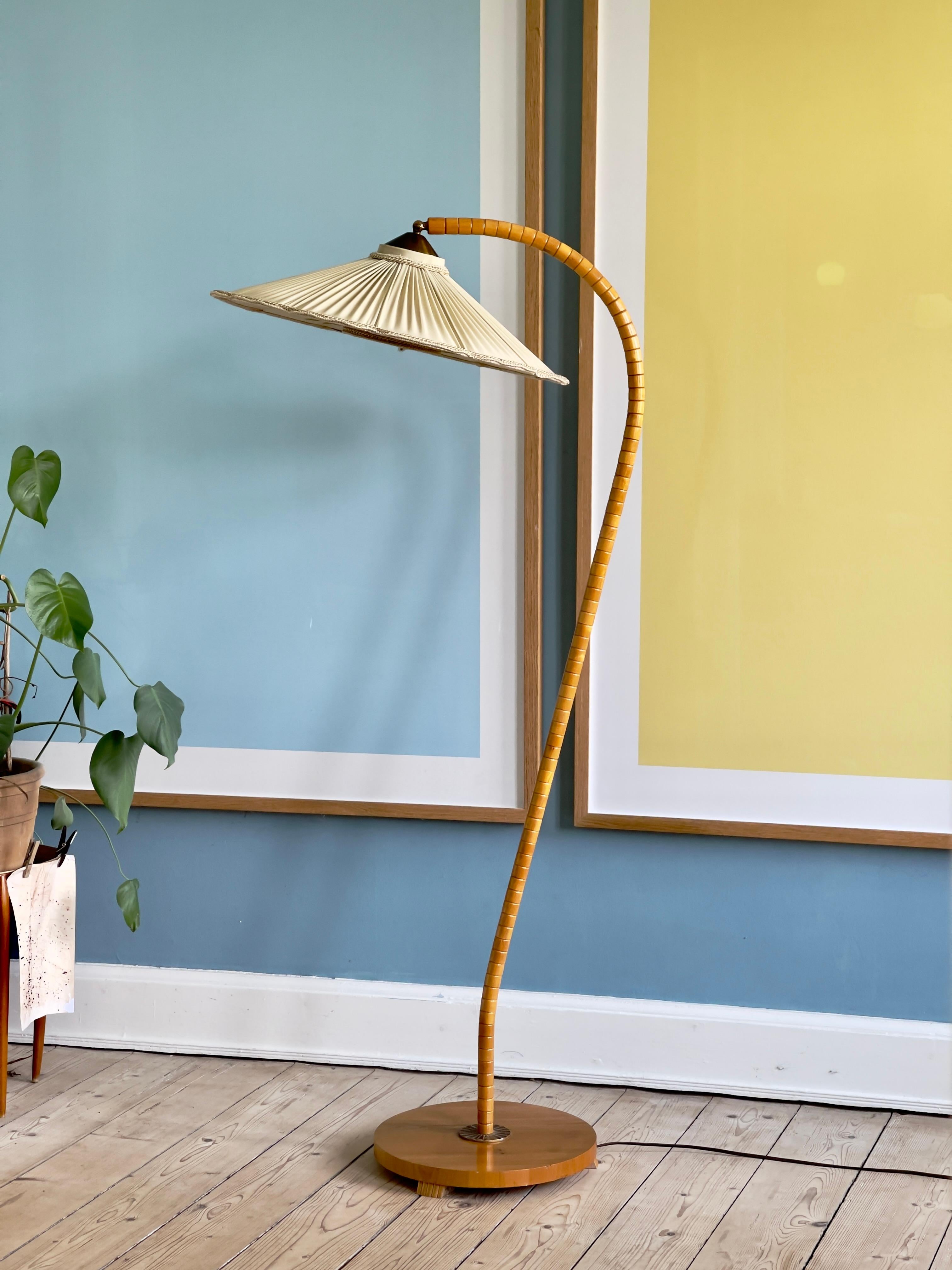 Seltene originale schwedische moderne Stehlampe aus den 1940er Jahren aus massivem, goldfarben patiniertem Ulmenholz mit schönem handgemaltem Vogelmotiv auf dem Leinenstoffschirm. Der Schirm ist mit einer filigranen Messingbefestigung montiert. Dem
