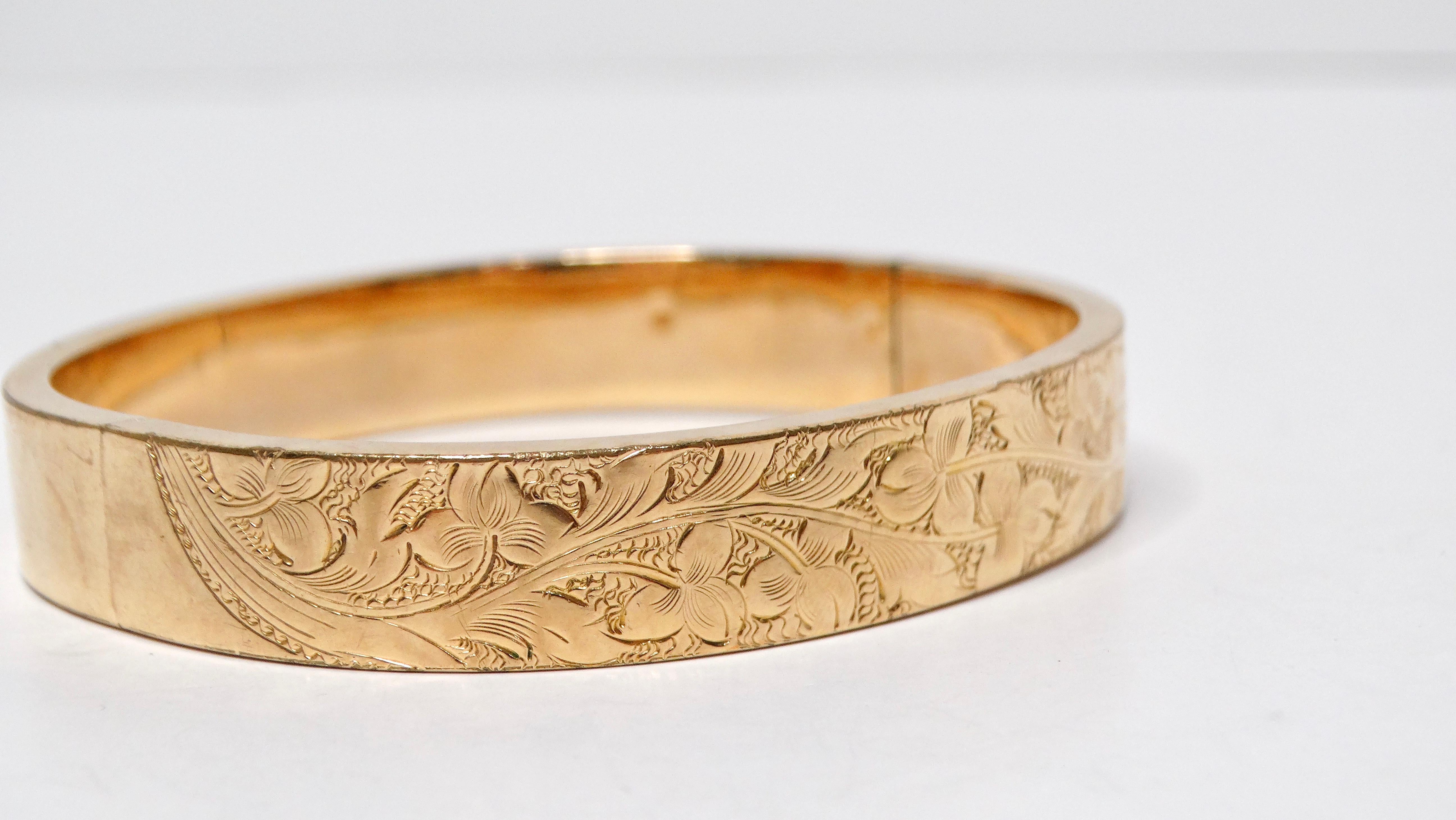 The 1940s Floral Print Engraved 14k Shell Gold Bangle combines elegance and vintage charm, making it a standout accessory for any jewelry collection. With one side adorned in a delicate floral engraving, it captures the intricacies of nature's