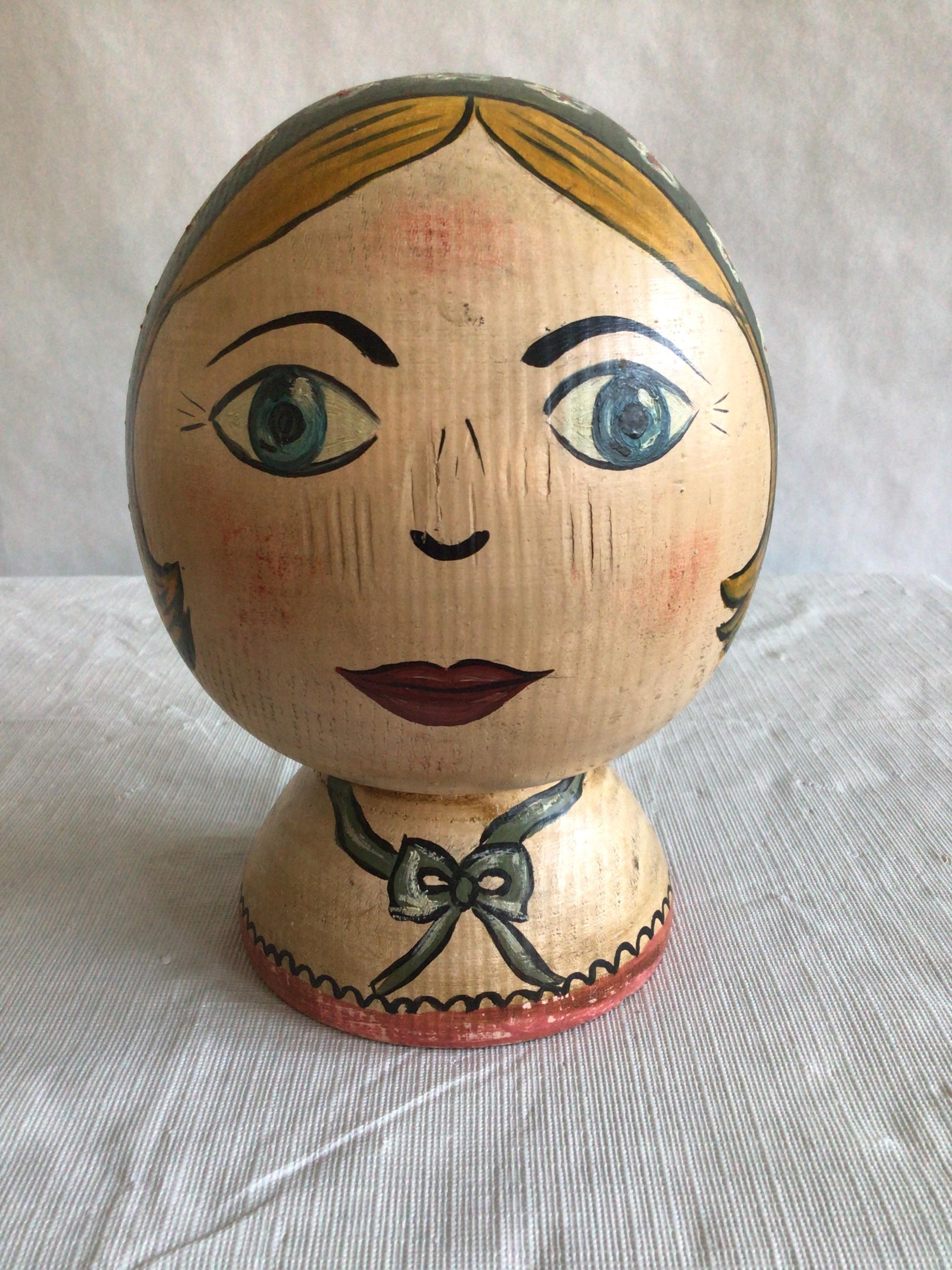 Questo charme di Folk Art / Epoca della Depressione, dipinto in legno, raffigurante una testa di donna, risale al 1940.  aggiungerebbe un pizzico di allegria e di fantasia a qualsiasi arredamento tradizionale.
I colori giallo, grigio, blu e rosso e