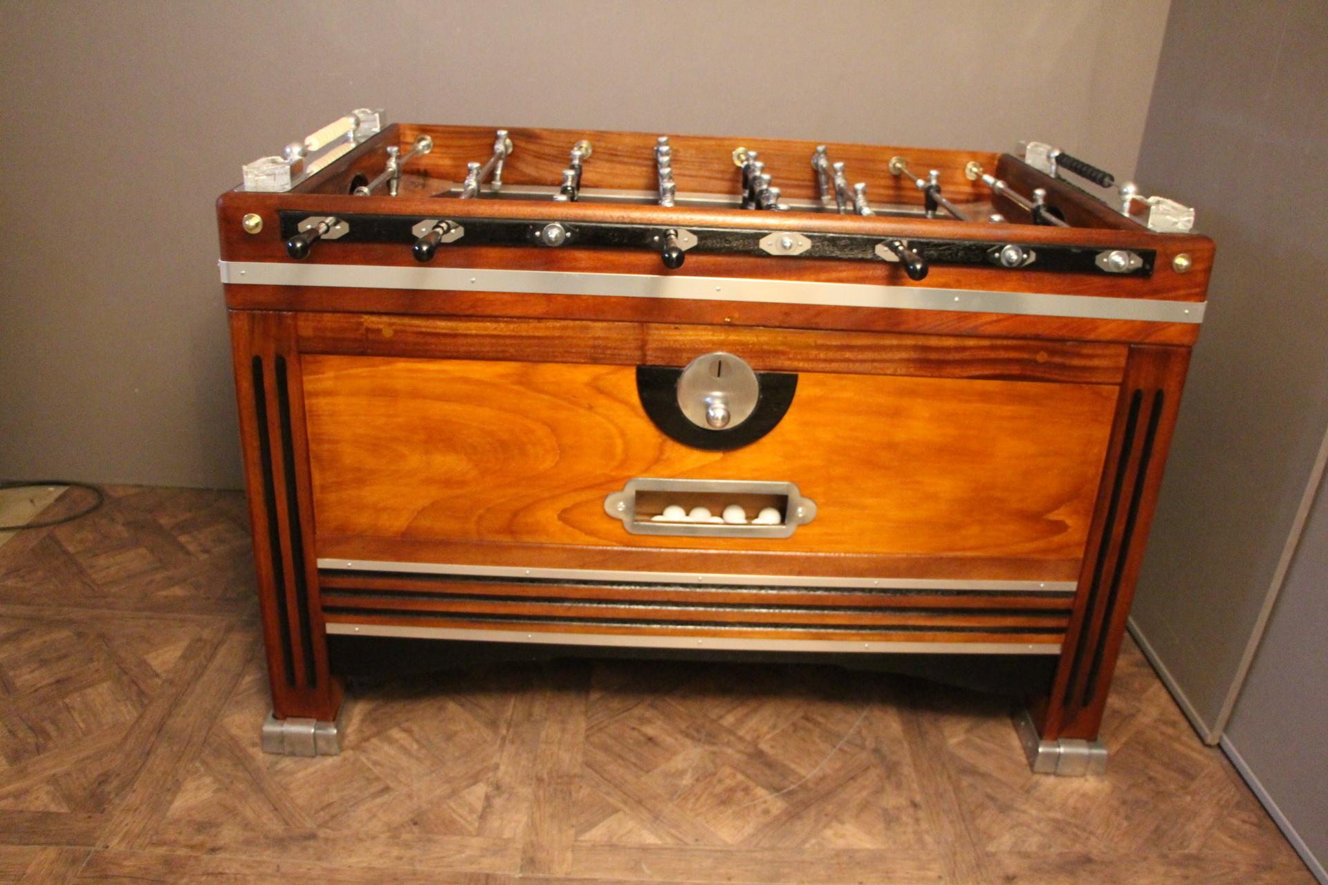 Unusual shape of French foosball table, this item is spectacular. It is in light color wood and blackened wood and features many aluminum pieces. 
Its players are in black and silver polished aluminum.
Black field and four Lalique crystal
