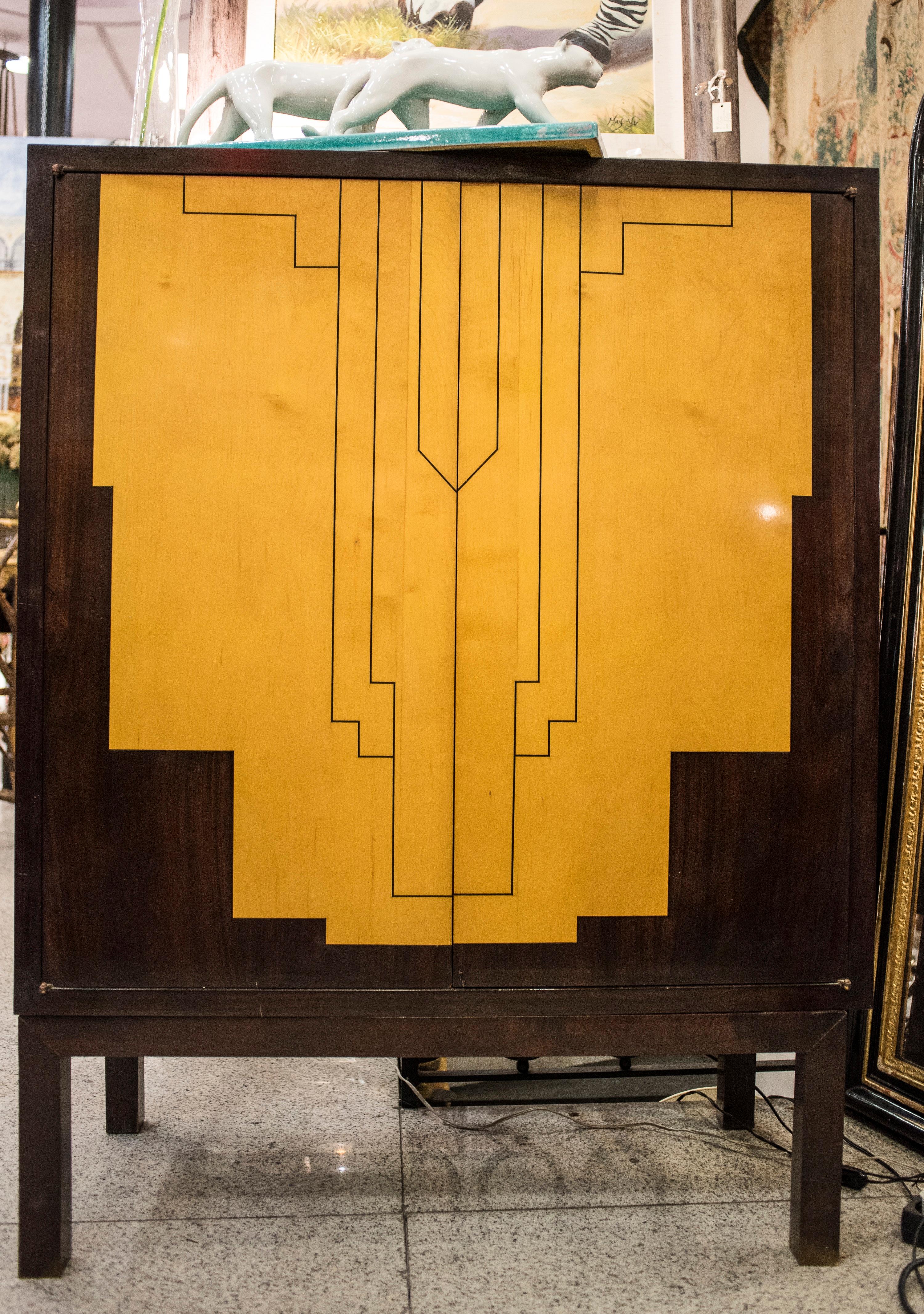 One of a kind late French Art Deco, in rosewood and lemongrass marquetry making a geometric drawing in the doors .Solid rosewood in all cabinet. Interior with shelves , but it can be used for a dry bar too.
It comes from a private South France