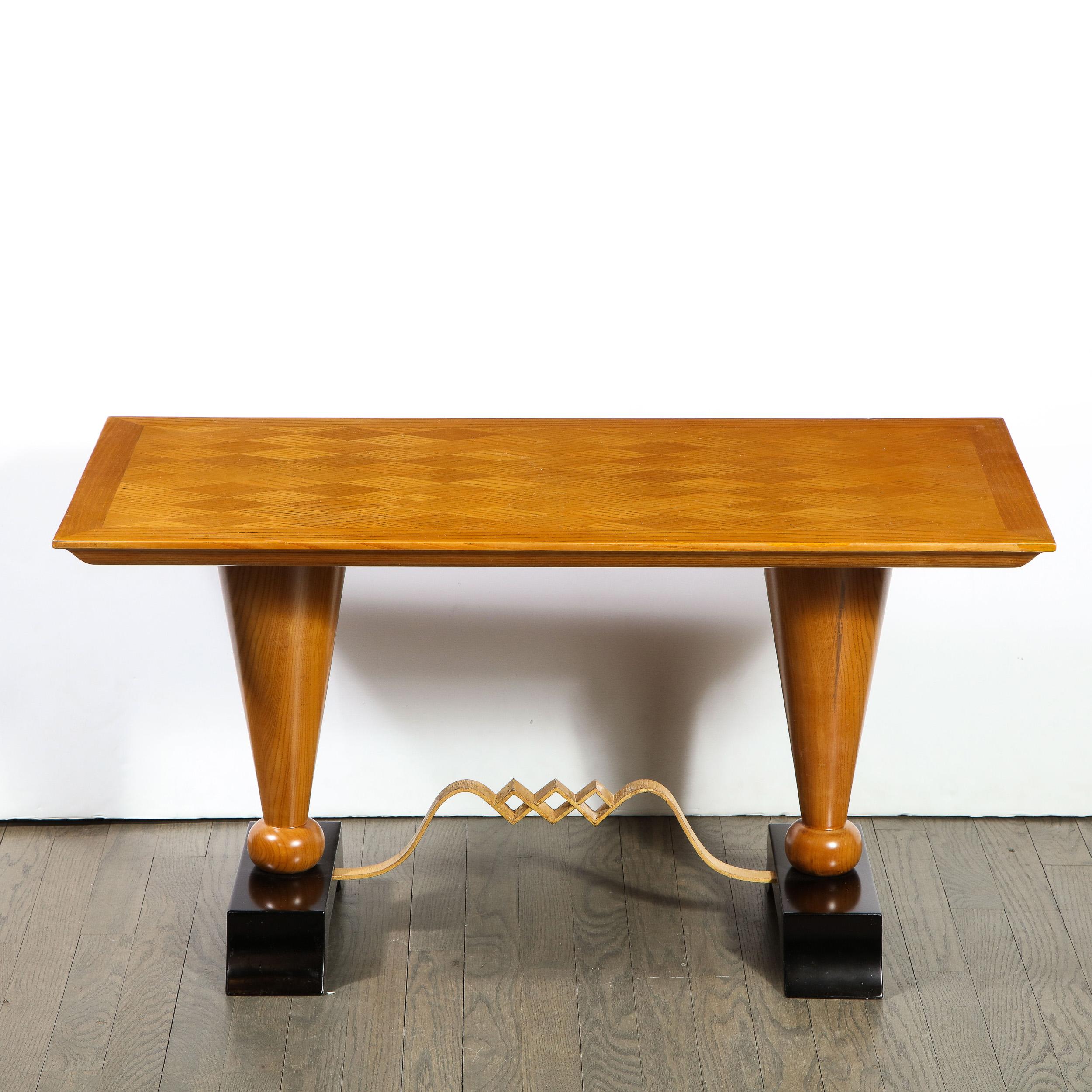 This elegant Art Deco cocktail table was realized in France, circa 1940. It features a rectangular blonde sycamore top with diamond form bookmatching in which the woodgrain of the walnut panels meets at perpendicular angles creating a rhythmic