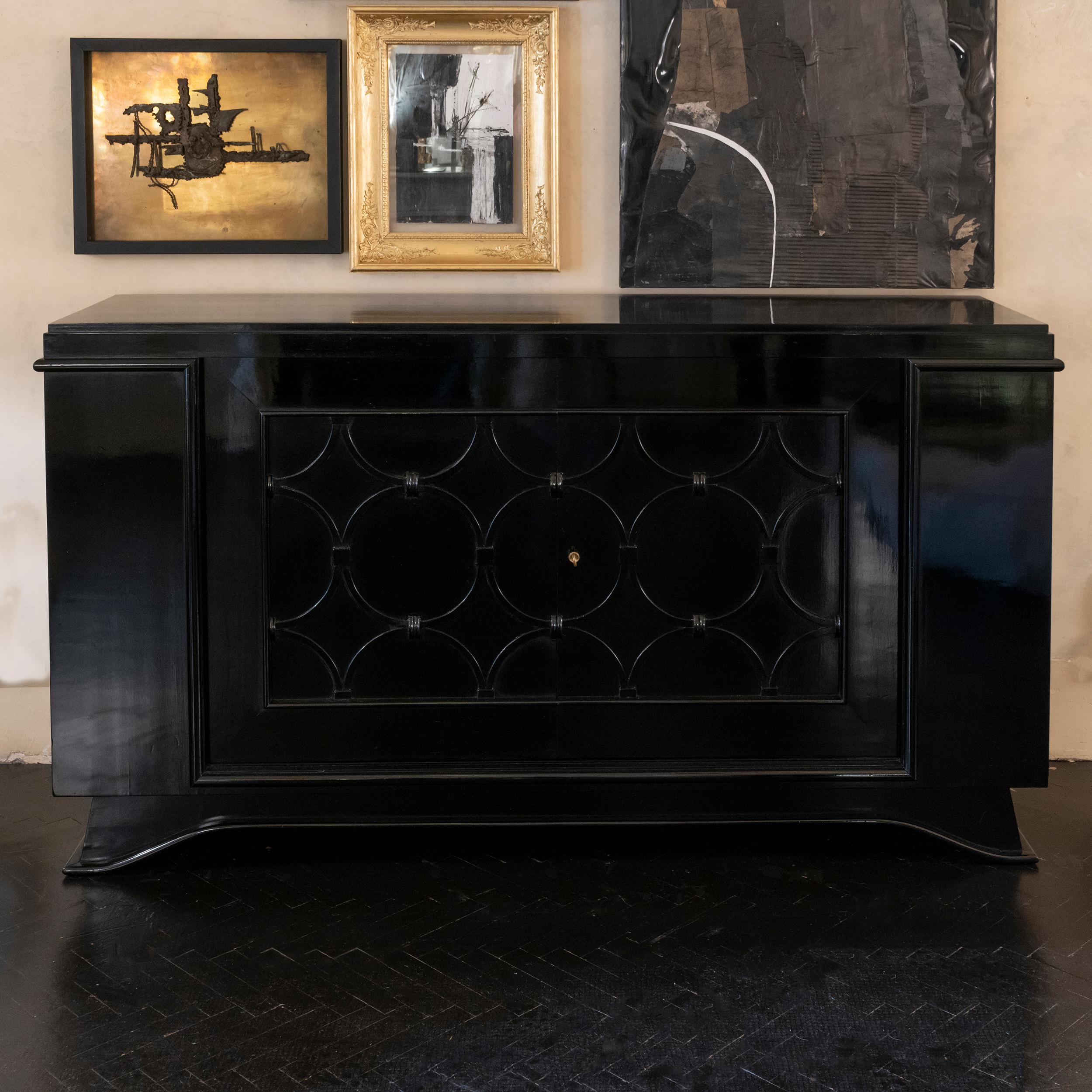 1940's French credenza in solid oak with black shellac finishing, geometric circular motif on the 2 doors, three drawers and one central shelve slightly curved, original brass key.