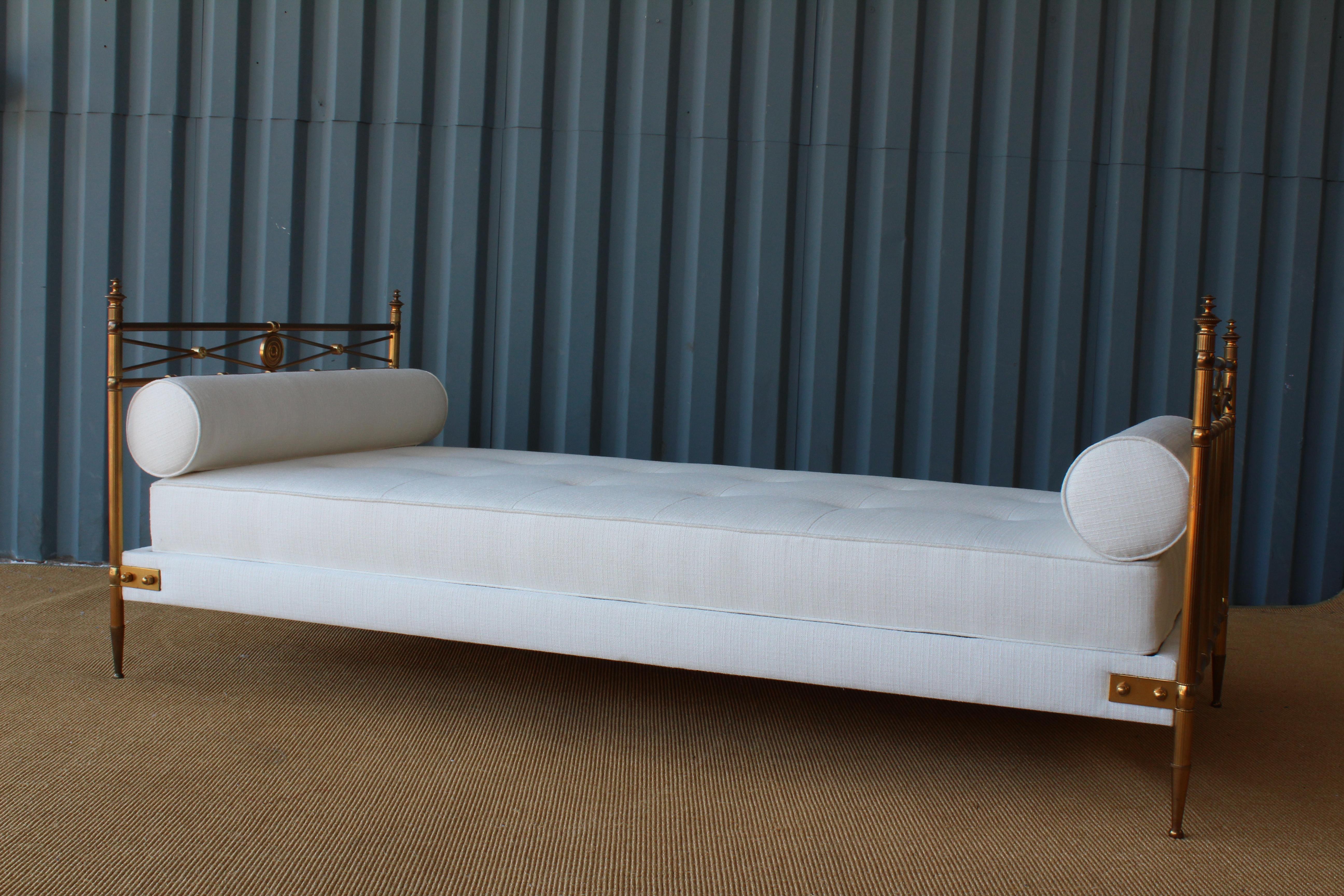 Beautiful French brass daybed in the manner of Maison Jansen. Newly upholstered in an off white performance fabric with two bolster pillows. Brass frame has a wonderful patina.

 