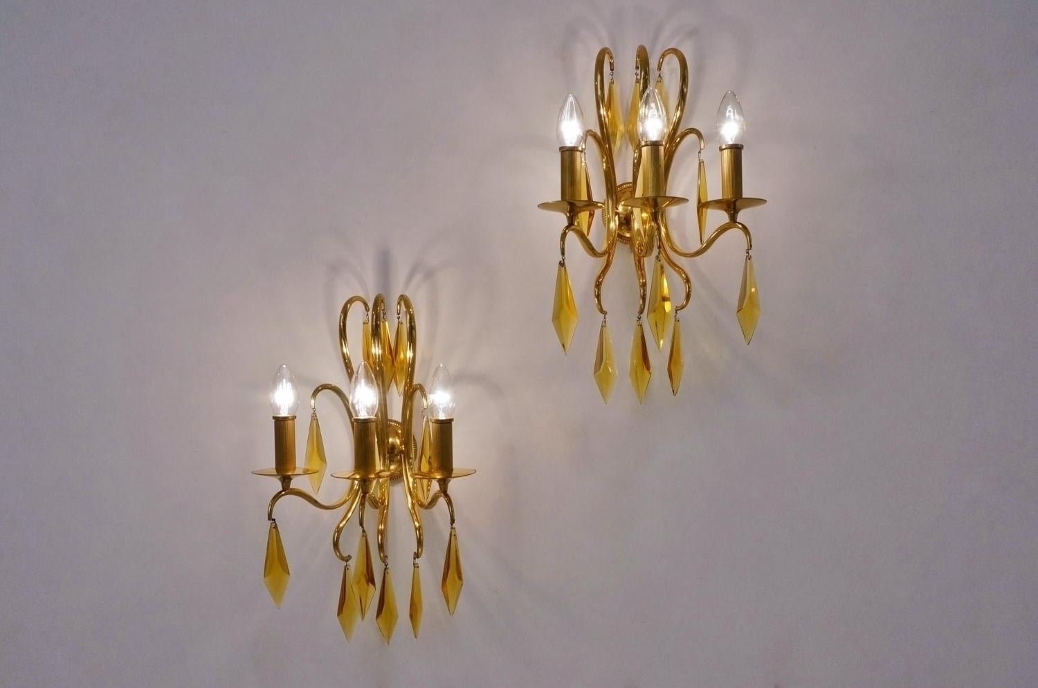1940s French bronze wall lights attributed to André Arbus. Each wall light is finished with 12 elegant amber faceted crystals which add to this sense of movement and glamour. The swirling metal work has a unique almost 'whiplash curves'