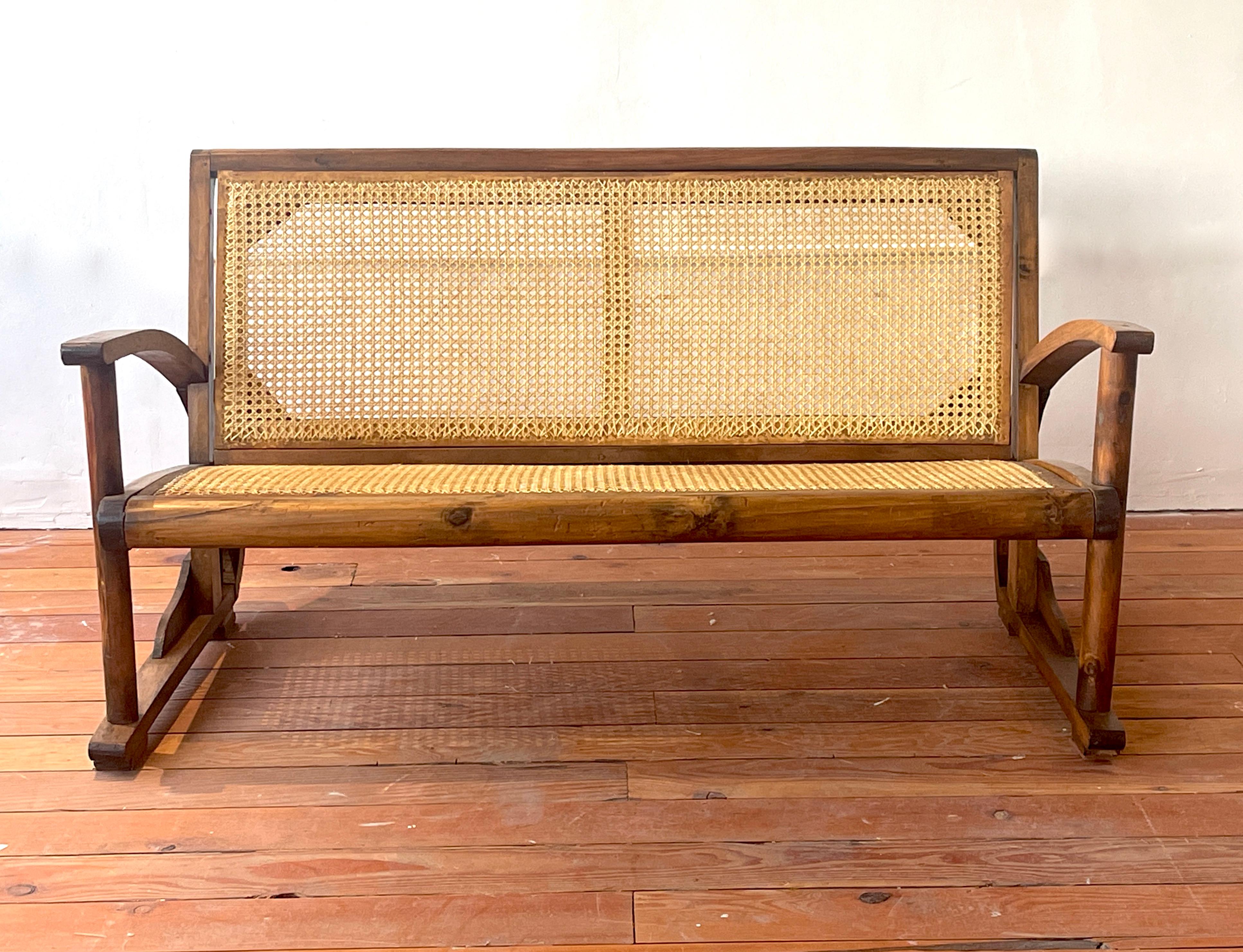 Art Deco bench in oak with caned seat and back, France circa 1940's
Great curved shaped arms 
Wonderful patina.