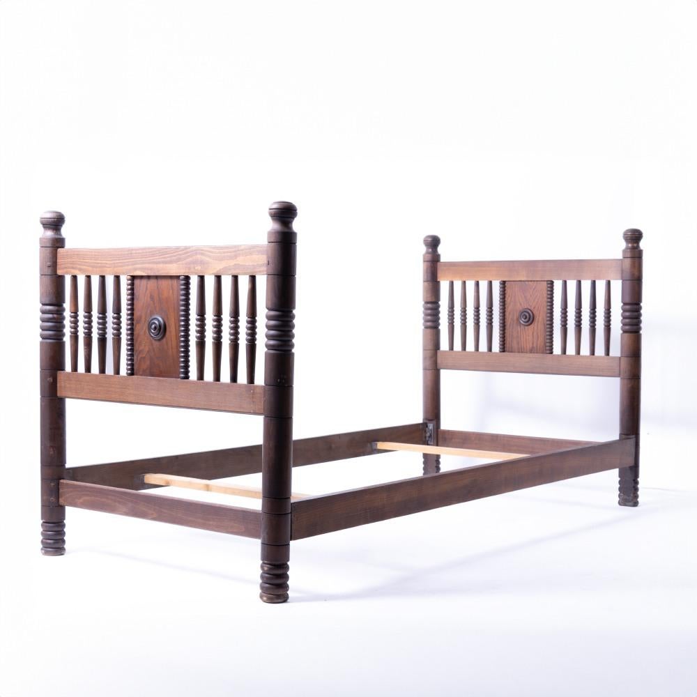 Incredible and rare vintage twin bed frame by Charles Dudouyt, circa 1940's France. Long oak wood frame with carved spindle and circle detail. Original finish shows nice age and patina. Includes side rails and two slats. Beautiful statement piece.