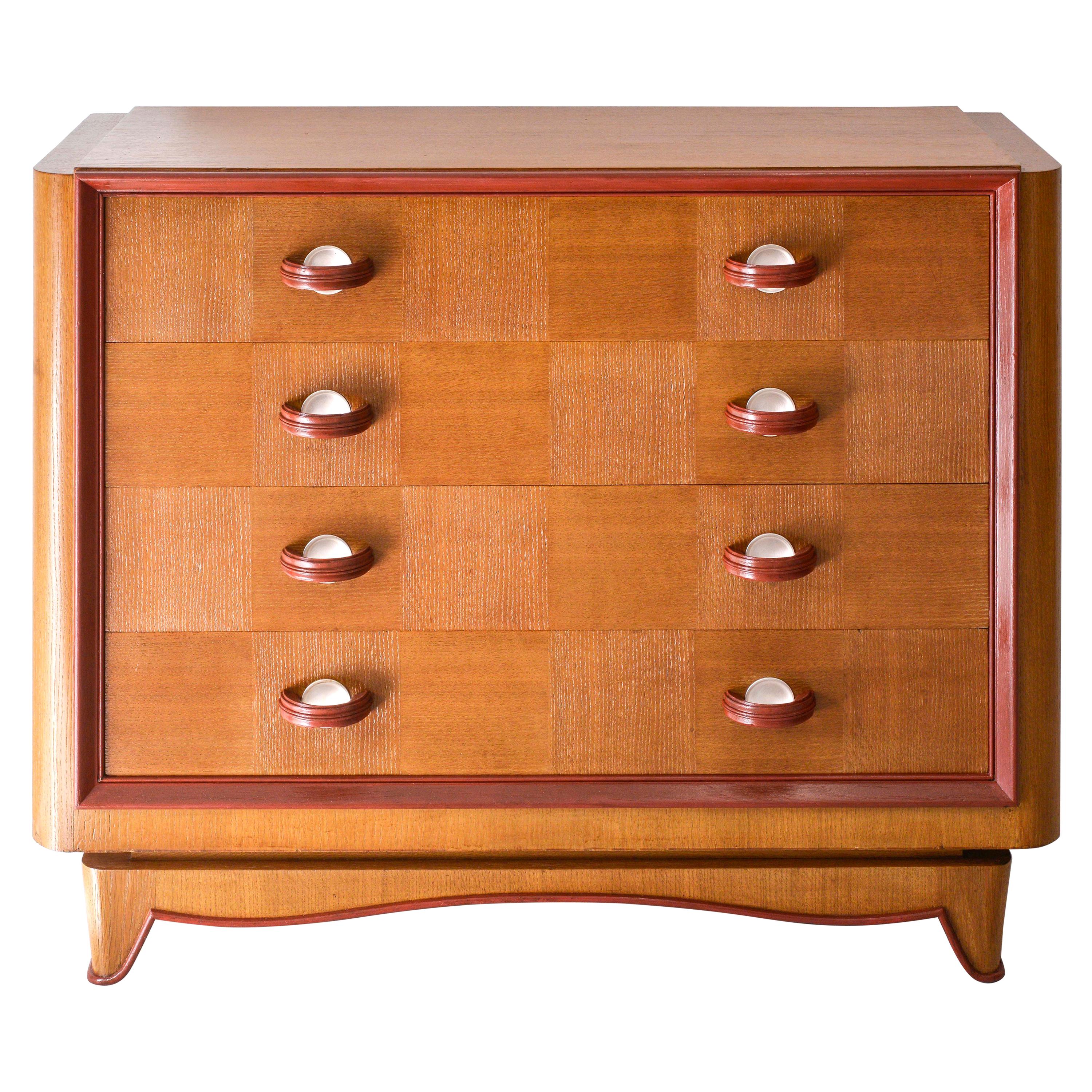 Rectangular top over four drawers fitted with original bronze (silver leaf) and wood handles; on elegant molded tapering base. Hermes red lines to highlight the elegant curves of this original vintage case piece in perfect condition. This cabinet