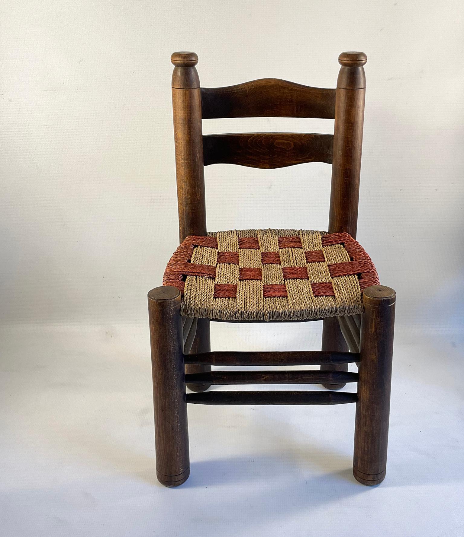 Single rustic dining chair by Charles Dudouyt with a unique two-tone red and natural rush weave.

