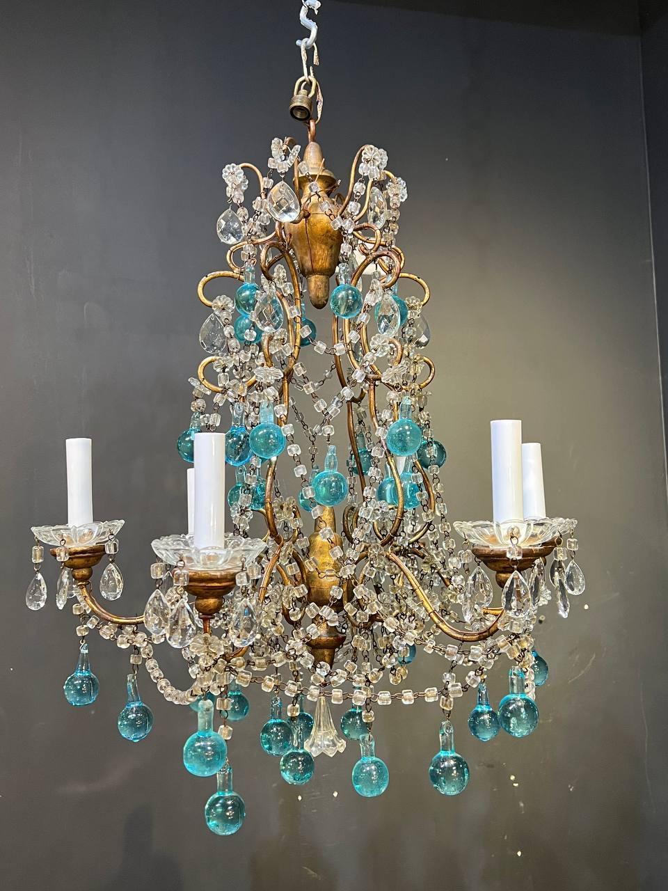 A circa 1940s French gilt metal chandelier with macaroni crystals and unusual blue crystal hangings.

Dealer: G302YP.
