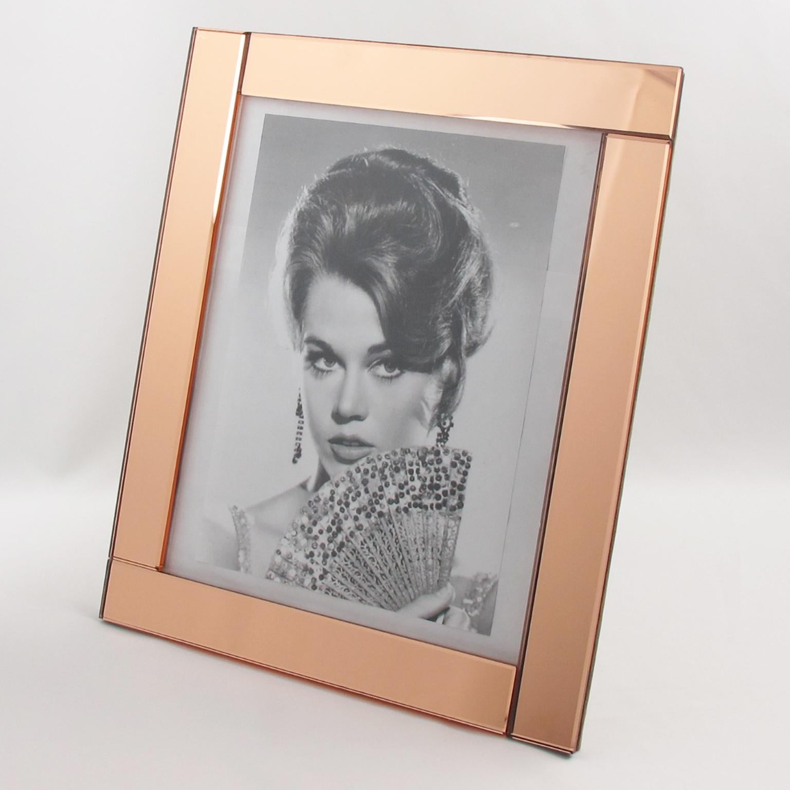 Elegant 1940s French Hollywood Regency mirrored picture photo frame. Deep bevelling and large flat sides in lovely copper or peach color. Frame can be placed either in portrait or in landscape position. Back and easel in decorative beige suede
