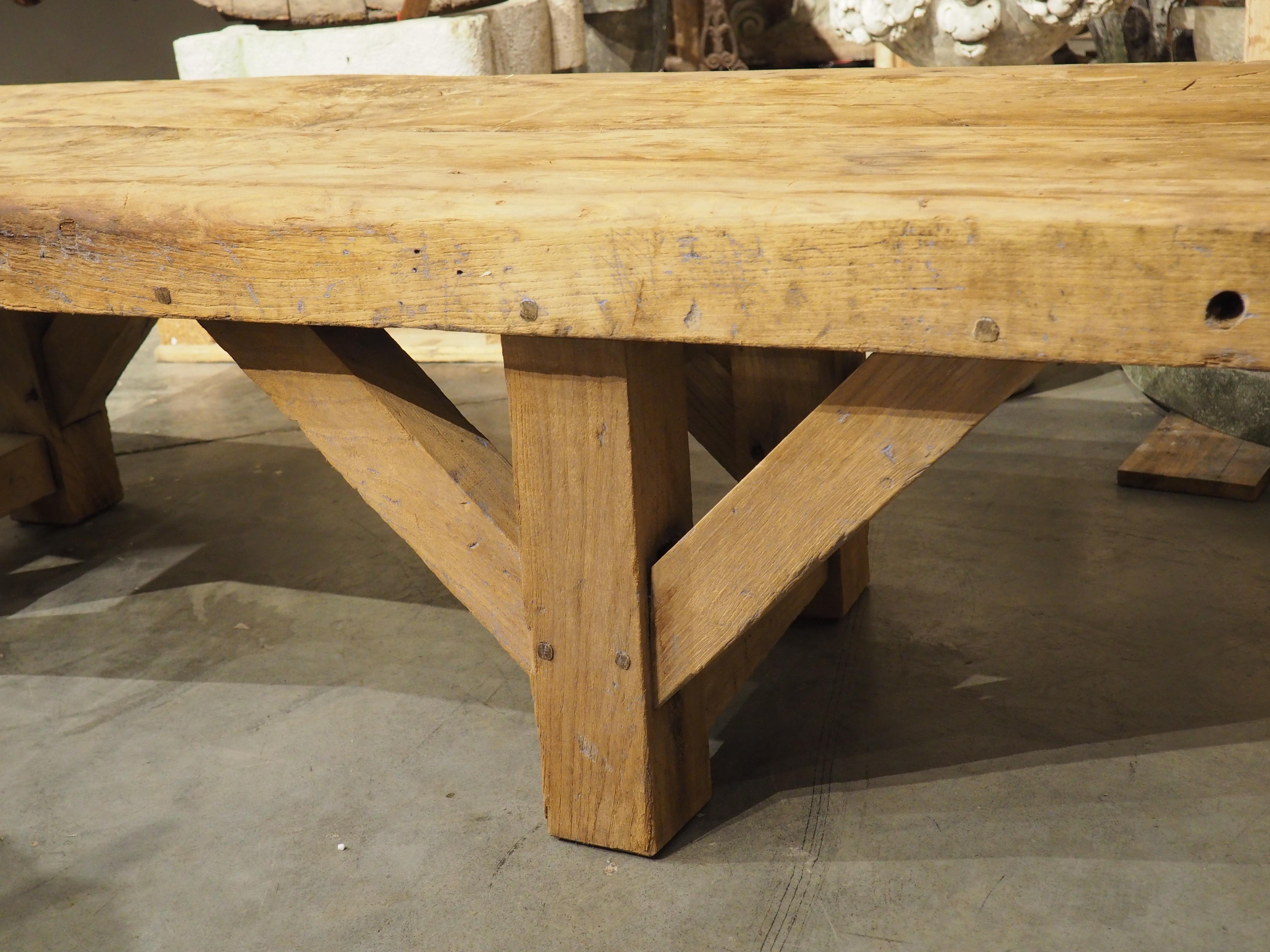 Pieza versátil de mobiliario francés, tallada a mano en los años 40 en Francia, este banco de aviación de madera de olmo se habría utilizado en un taller industrial. Tres patas de celosía sostienen la robusta encimera de 5 cm de grosor, formada por
