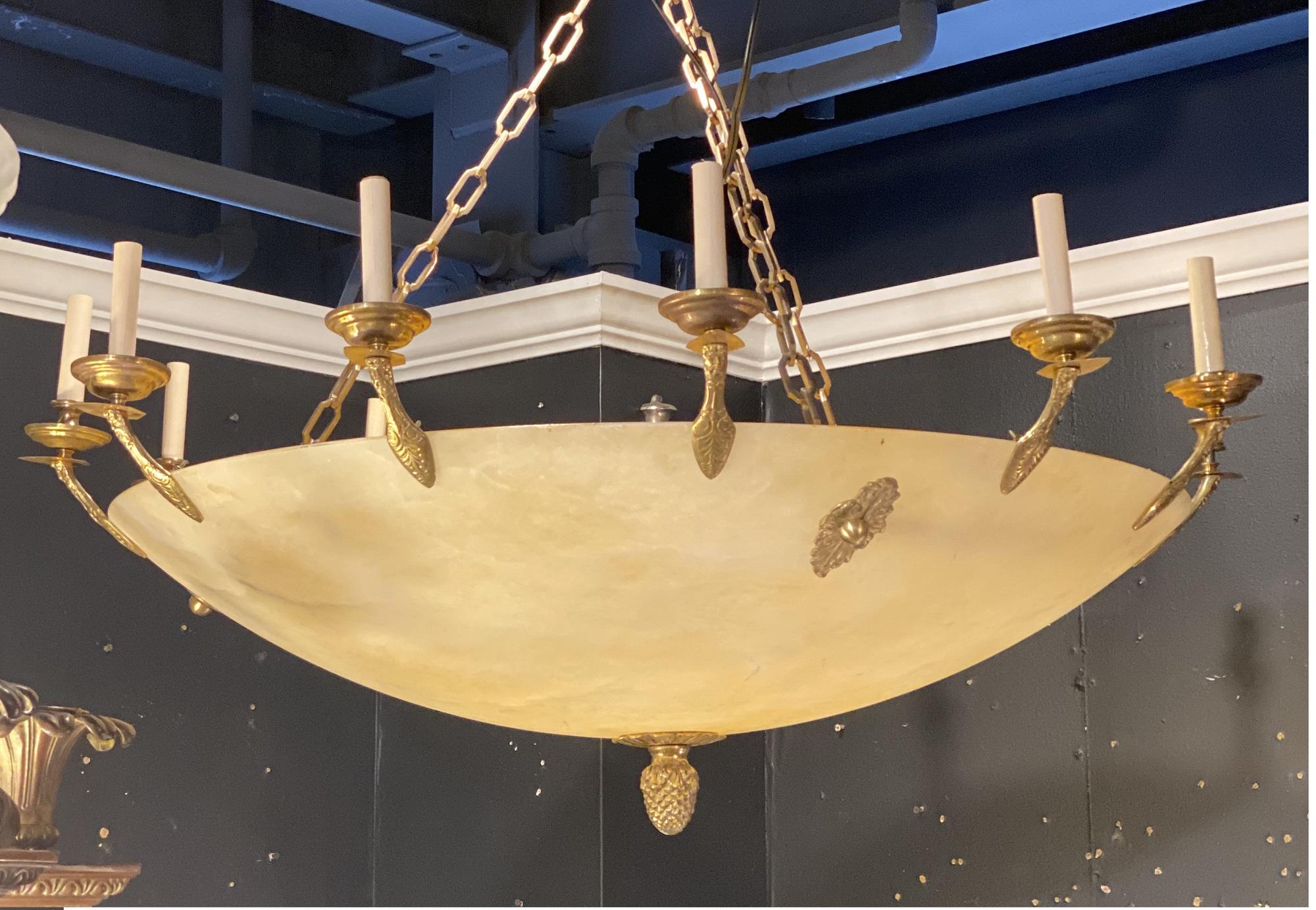 A circa 1940’s French empire style alabaster chandelier with bronze interior arms, 12 lights + 6 interiors.
