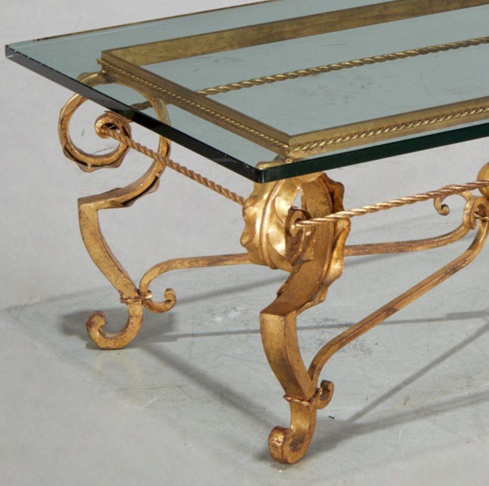 Table basse en verre et fer forgé doré des années 1940 dans le style de la Maison Baguès. Cette exquise table basse vintage présente une base en fer forgé doré avec des volutes complexes, des détails de corde torsadée et une sphère centrale dorée,