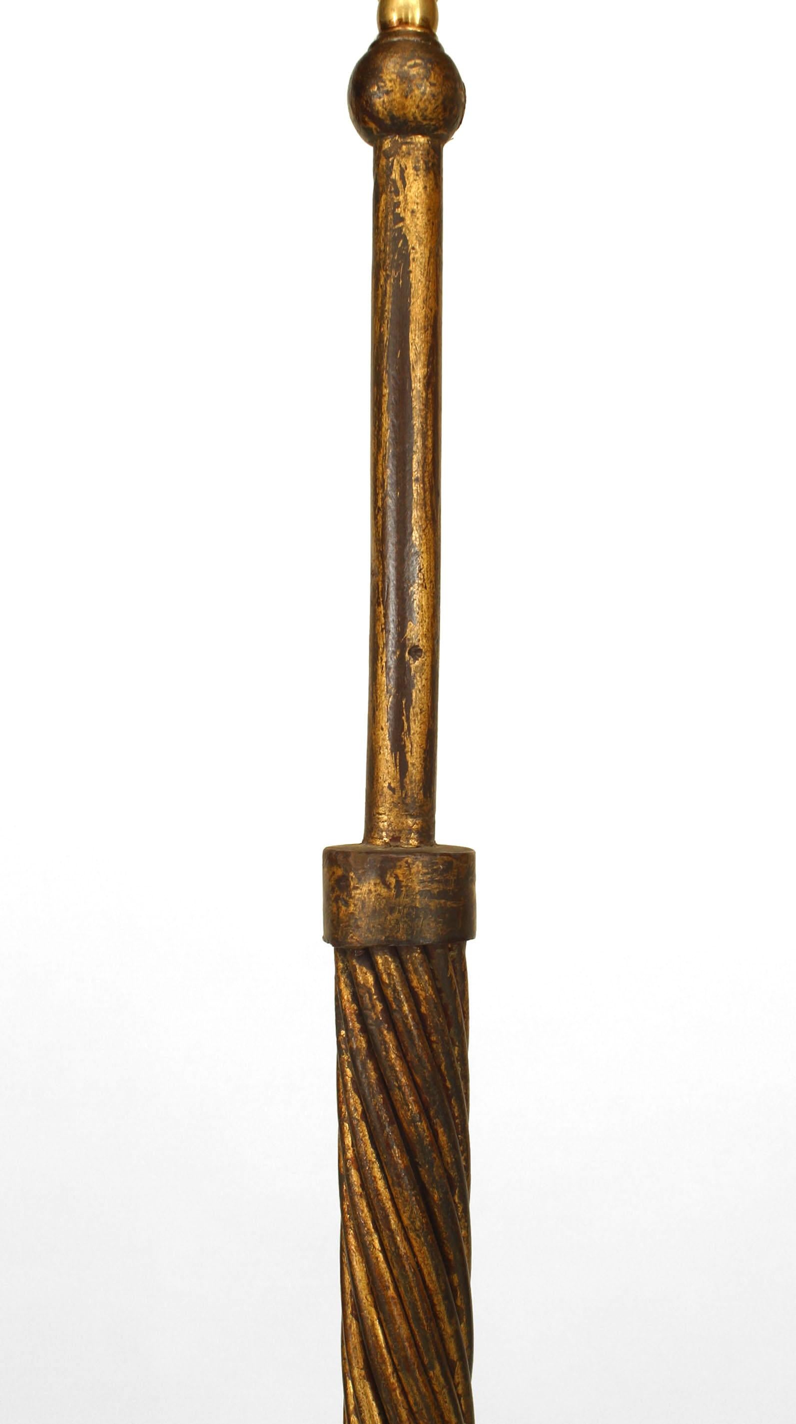 Lampadaire colonne en fer doré des années 1940 à motif de corde torsadée reposant sur une base à trois pieds (dans le style de POILLERAT).
