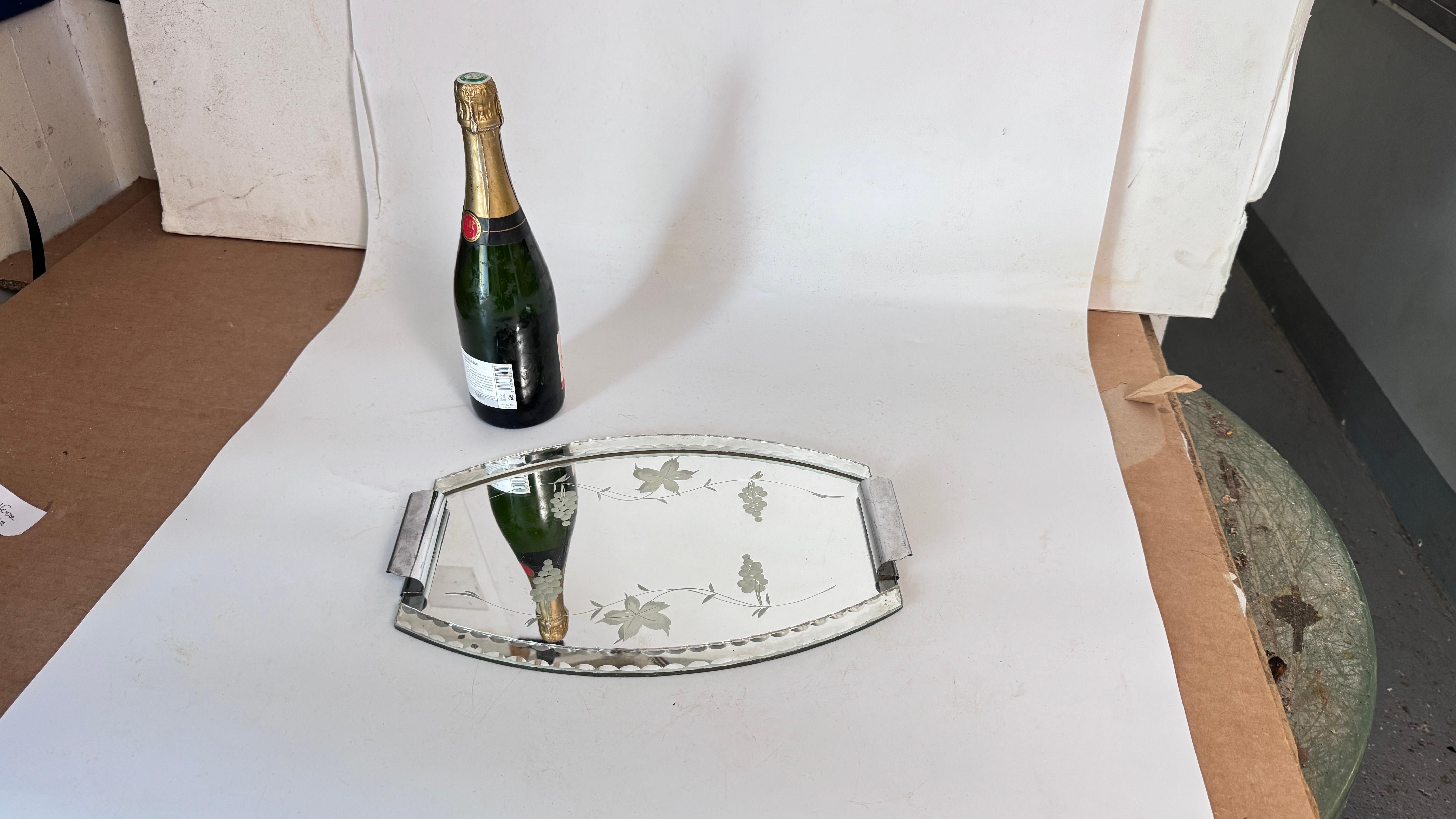 1940s French Glass and Mirror Tray – Beveled Edges – Floral and Grape Motif – Metal Handles

Description:
This elegant French glass tray from the 1940s features a mirror base with beveled edges and intricate decorative motifs etched into the