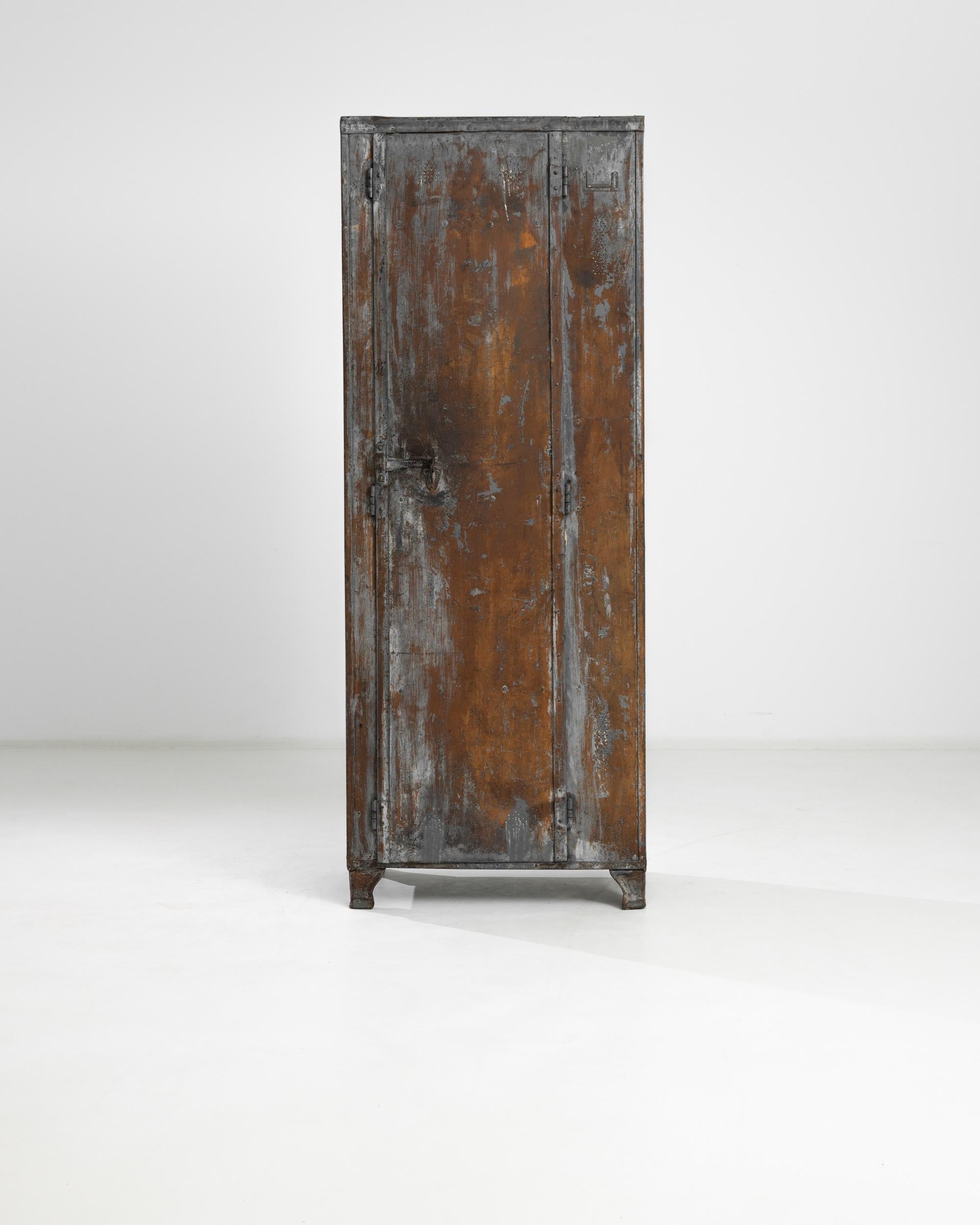 This 1940s French Metal Cabinet exudes a robust, industrial charm that's hard to find in modern furniture. Its distressed patina tells a story of years gone by, adding an authentic vintage appeal to any space. Standing tall on sturdy legs, this