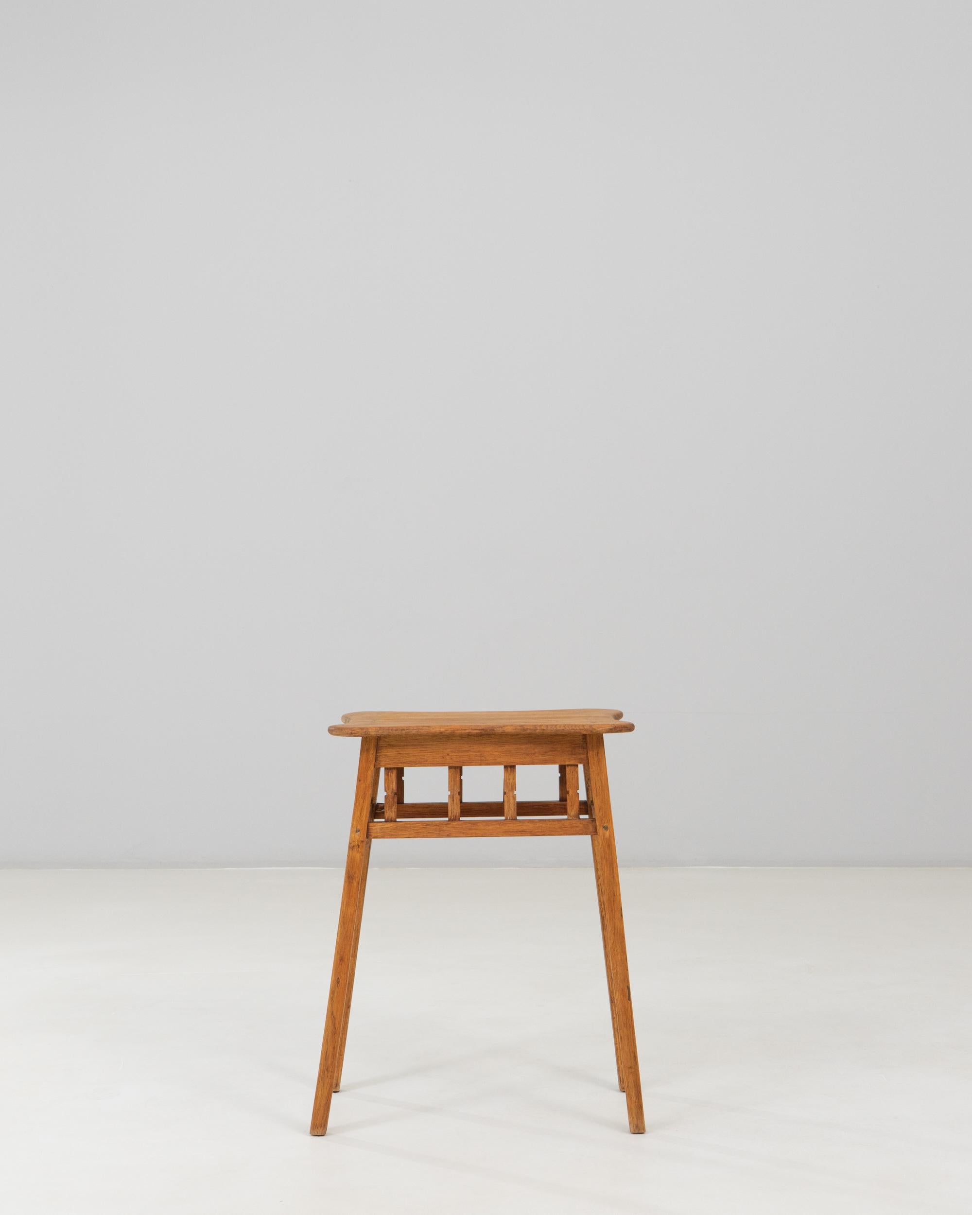 1940s French Mid-Century Modern Wooden Side Table. This charming mid-century side table showcases the clean lines and functional simplicity associated with early modern French design. Crafted from warm-toned wood, it features a gently contoured top