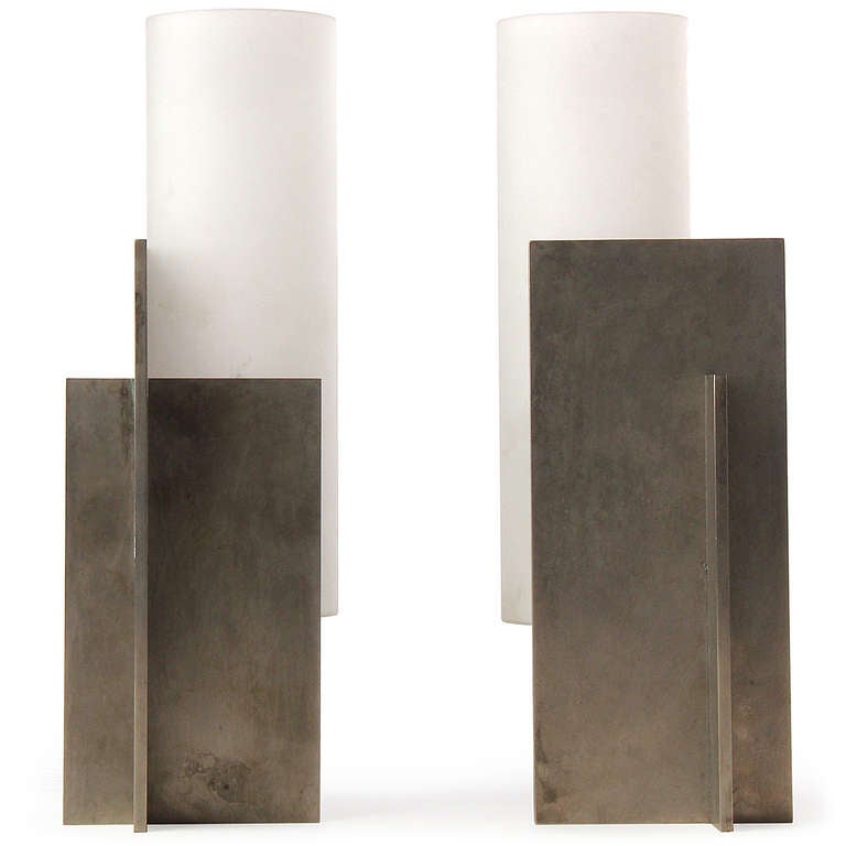 A striking and geometrically pure pair of Minimalist sconces formed from the intersection of two planes of patinated steel and the addition of a frosted glass column.