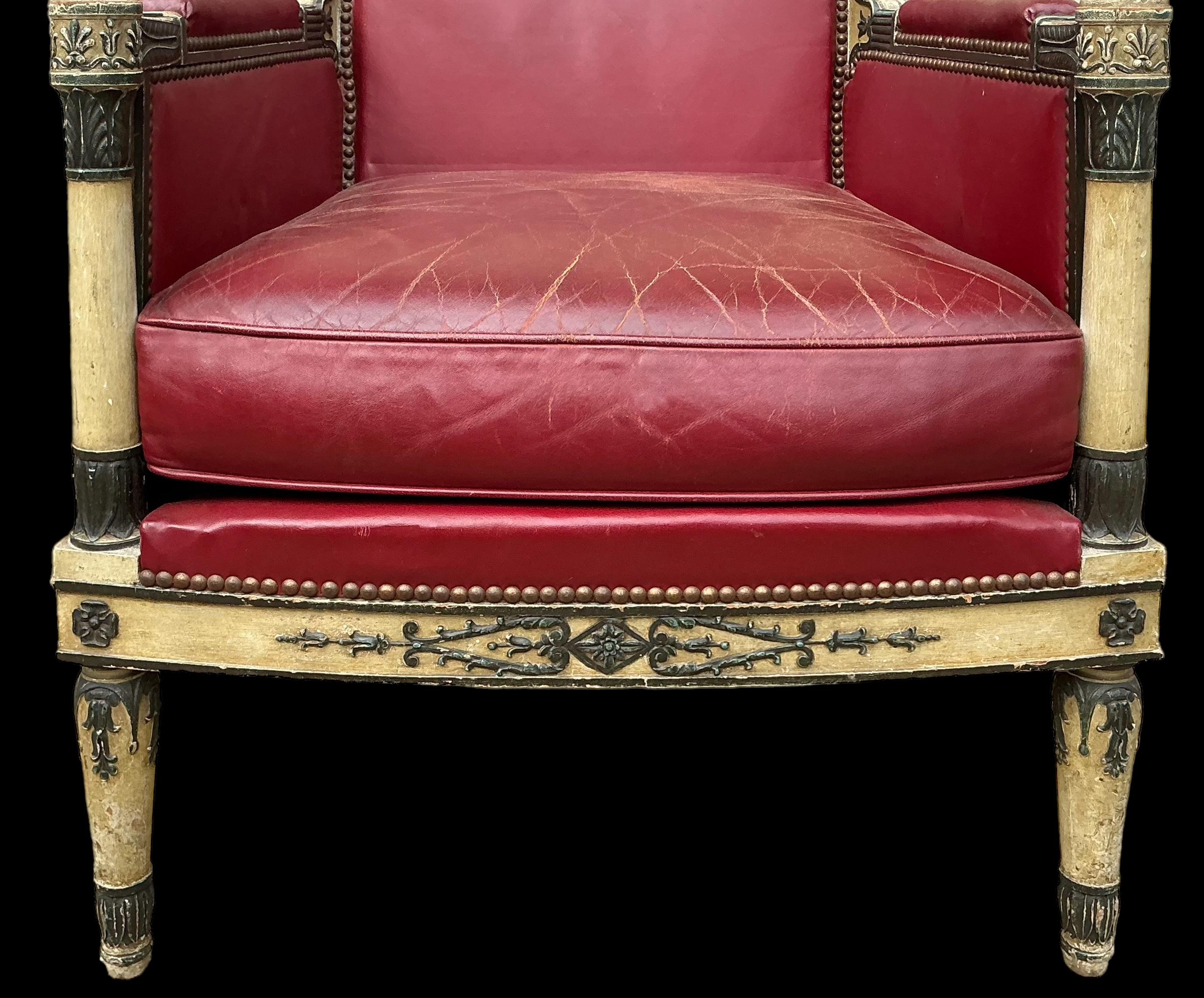 This handsome chair dates approximately to the 1940s. It has French styling but I believe it to be American. The ebonized details with the wonderfully patinated ochre backdrop just exude elegance. The garnet leather does show wear, and the back is a