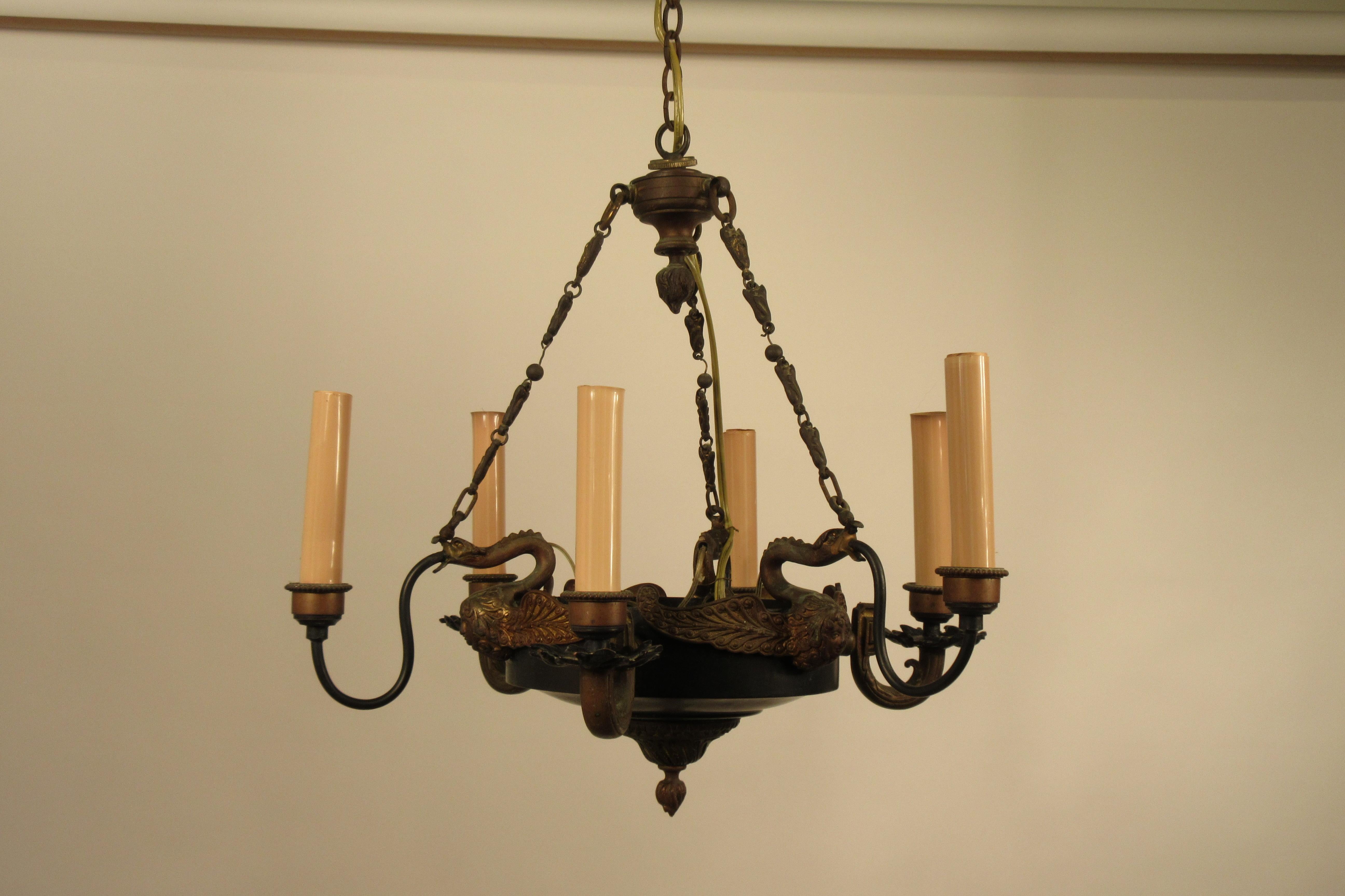 1940s French neoclassical small chandelier adorned with swan heads and faces. Brass and tole.