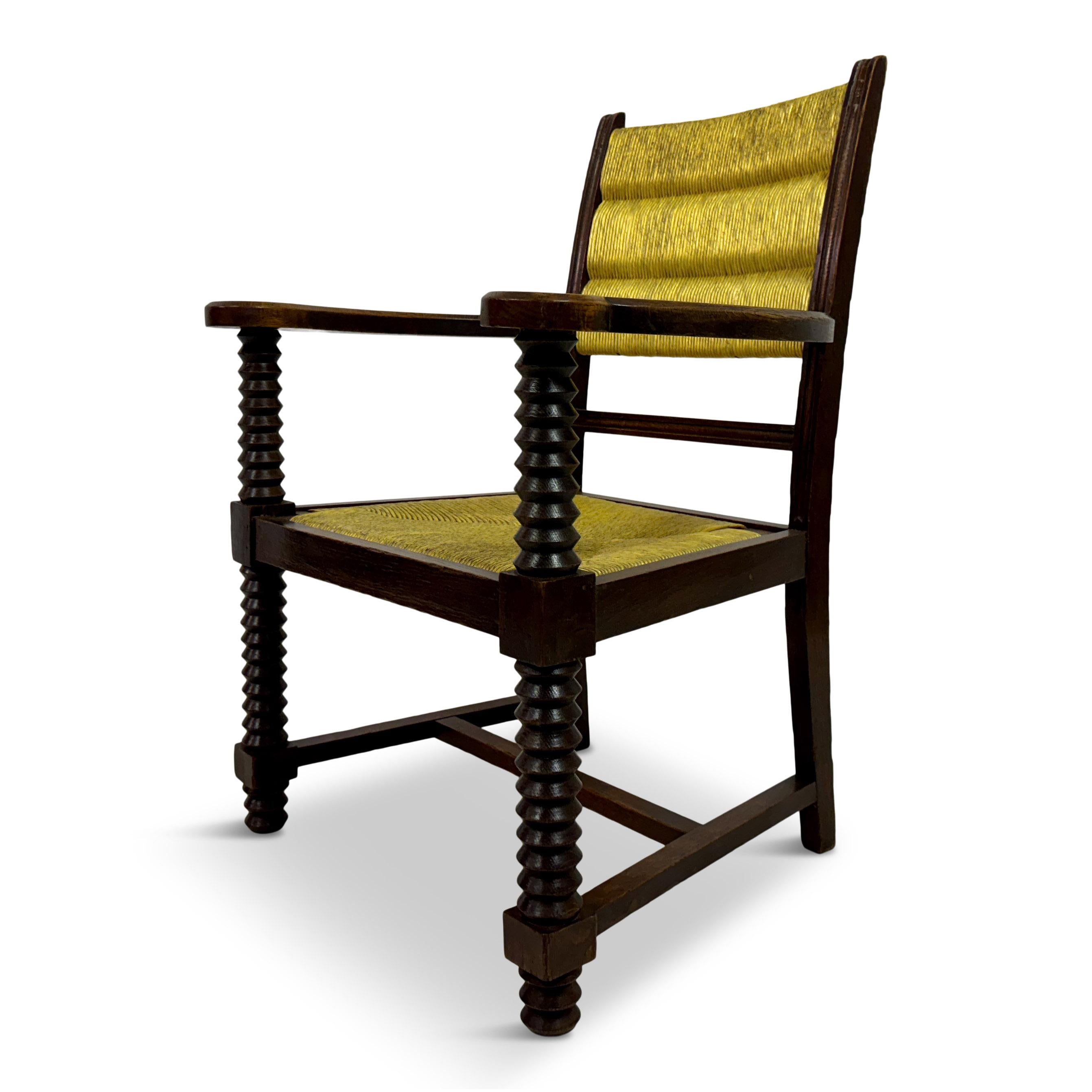 Armchair by Charles Dudouyt

This armchair has a sturdy, rustic design with intricate craftsmanship. The frame is made of dark oak wood, showcasing a rich, deep brown tone. The most striking feature of this chair is its carved spiral legs, adding