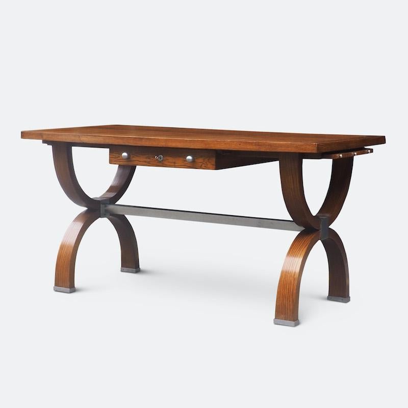 Bellissima scrivania francese degli anni '40 in Oak con ante laterali estraibili e cassetto centrale con serratura a doppia faccia, sostenuta da gambe a U con coda, rifinite con ferramenta in nichel spazzolato.