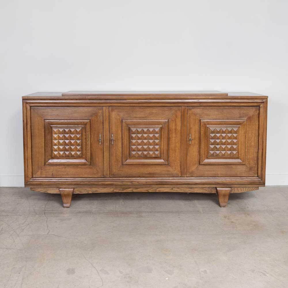 Incredibile credenza in rovere proveniente dalla Francia, anni '40. Bellissimi dettagli squadrati in legno intagliato sulle ante dell'armadio e sulle gambe curve. Tre ante si aprono su due ripiani interni. La finitura originale del legno presenta
