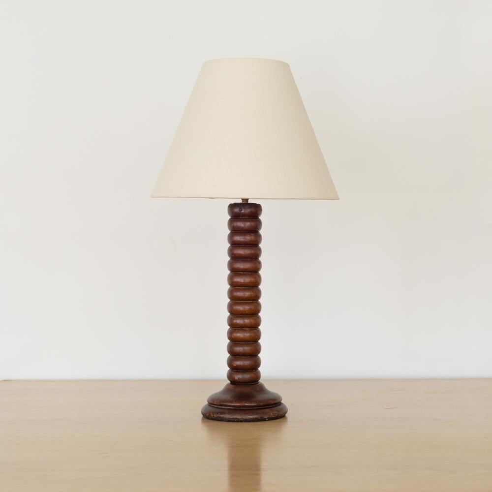 Magnifique lampe de table en bois vintage de France, années 1940. Épaisses rainures en bois sculpté sur la tige. Finition d'origine en bois foncé présentant une belle patine d'ancienneté. Le bois présente des marques et des rayures typiques de